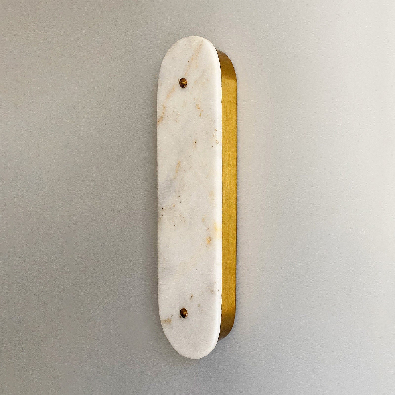 Close-up of the Fivorno Wall Lamp's marble lampshade and copper body.