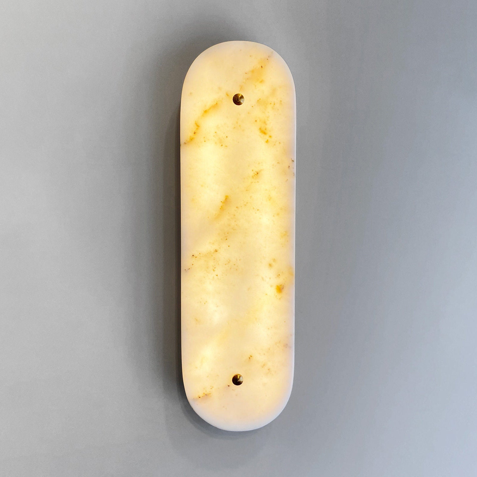 The Fivorno Wall Lamp illuminated, casting a warm and inviting glow.