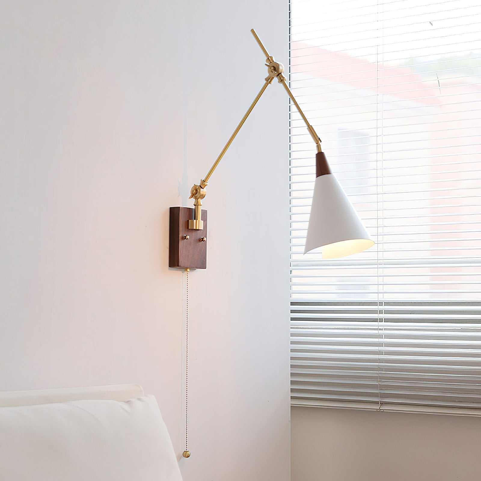 Close-up of the Fleka Wall Lamp's wood and brass articulating arm.