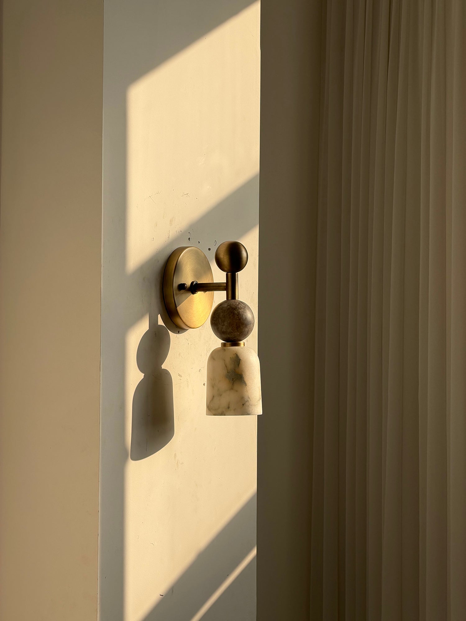The Flume Wall Lamp shown against a dark, textured wall.
