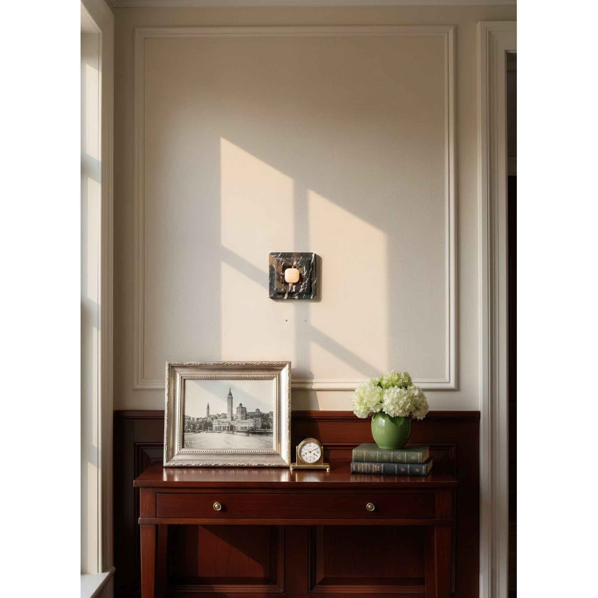 Black marble wall lamp illuminated in a dark room.