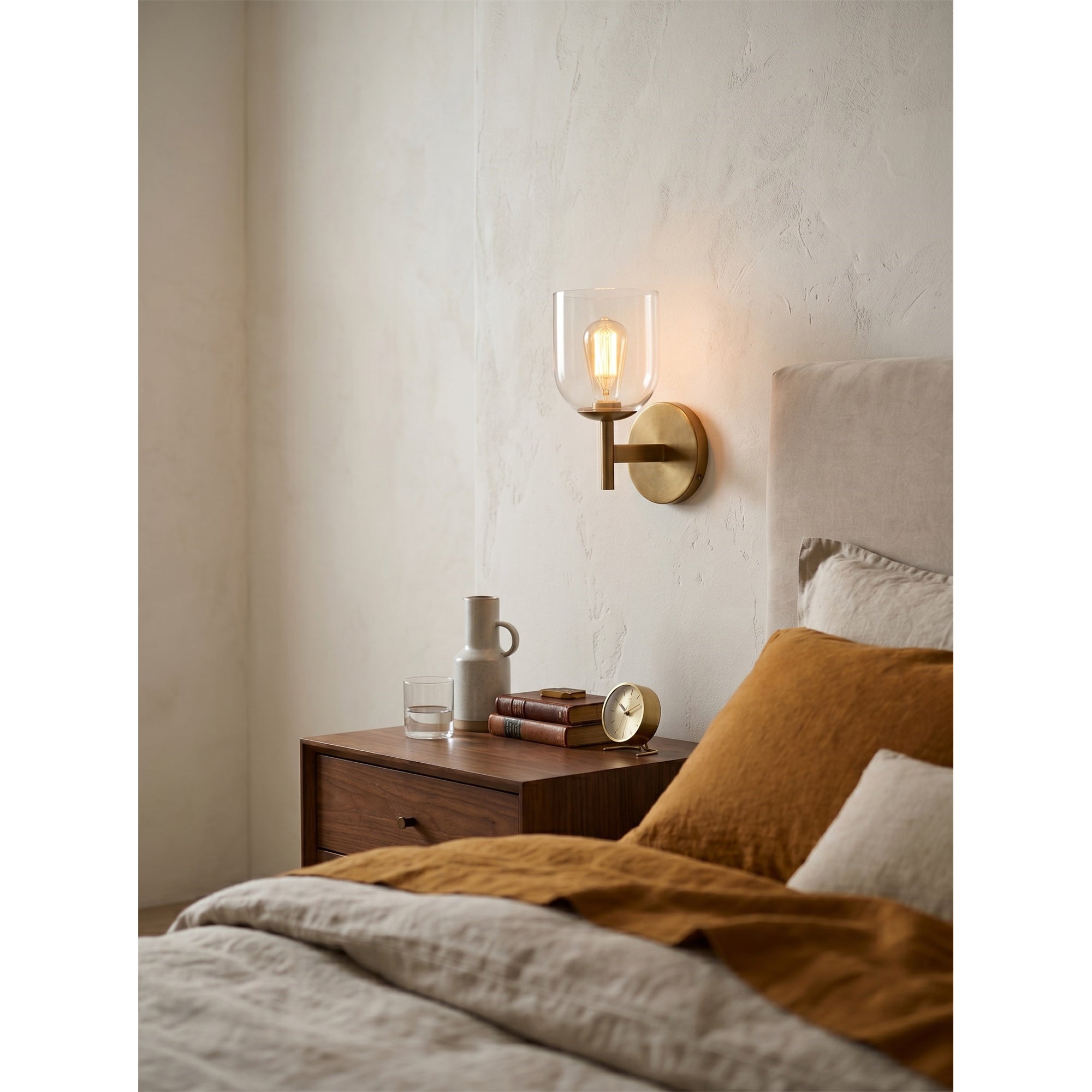 The wall sconce casting a warm glow in a dimly lit room.