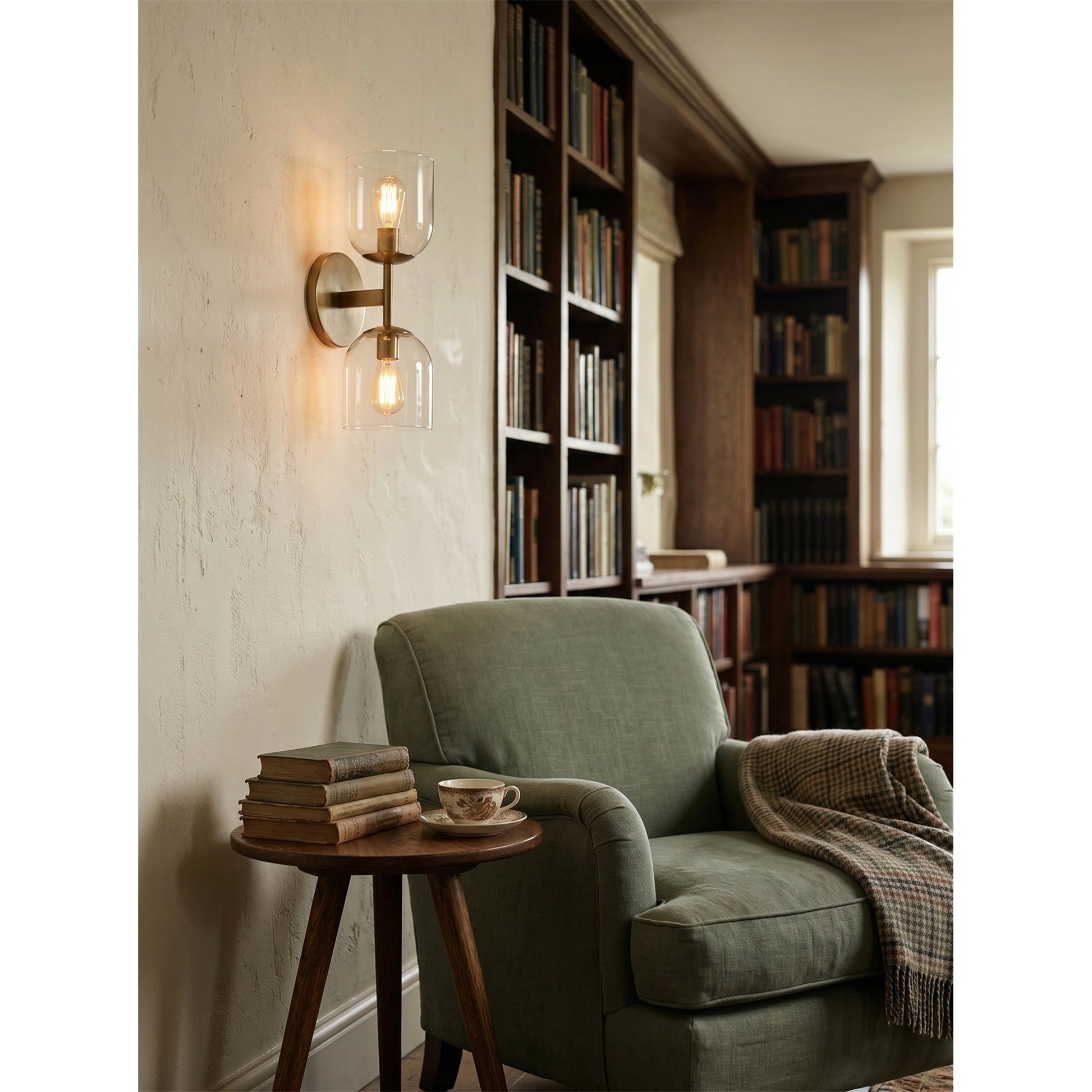 A pair of Garrison sconces flanking a round bathroom mirror.