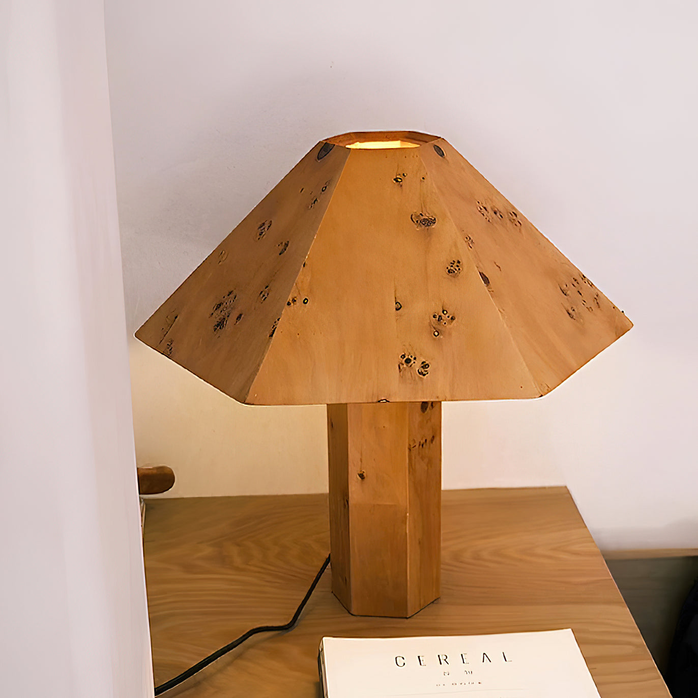 Gena Table Lamp on a side table next to a sofa.