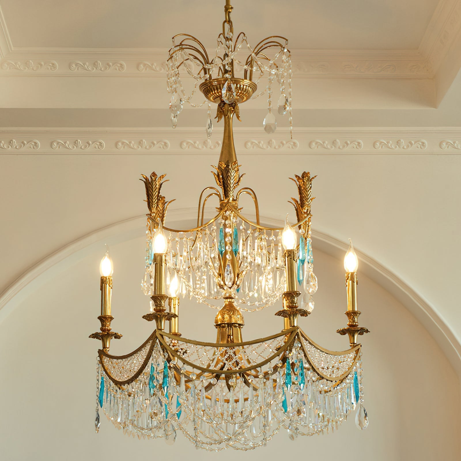 The chandelier shown in a grand foyer with a high ceiling.