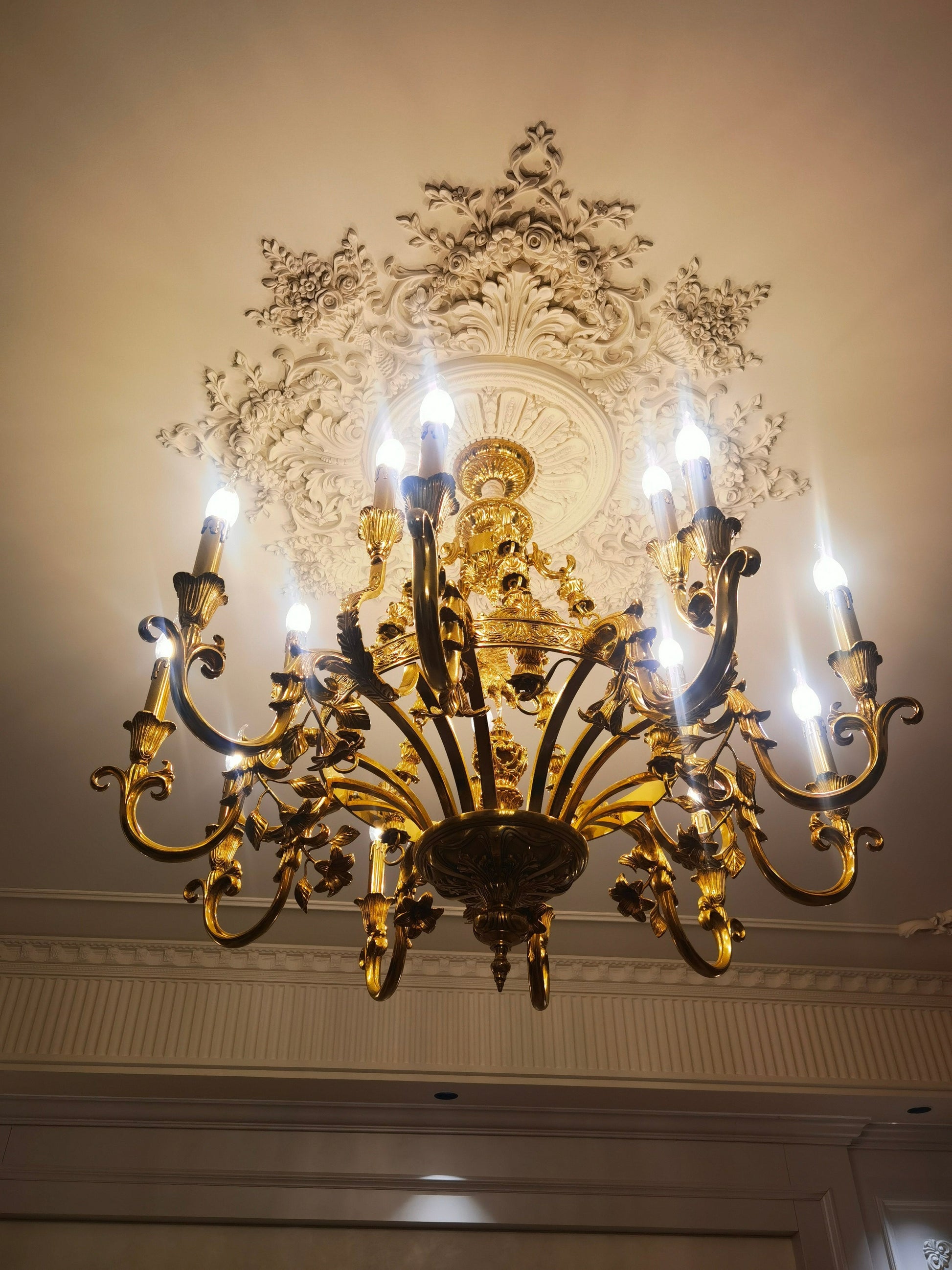 The polished brass finish of the Genualdi Chandelier in natural light.