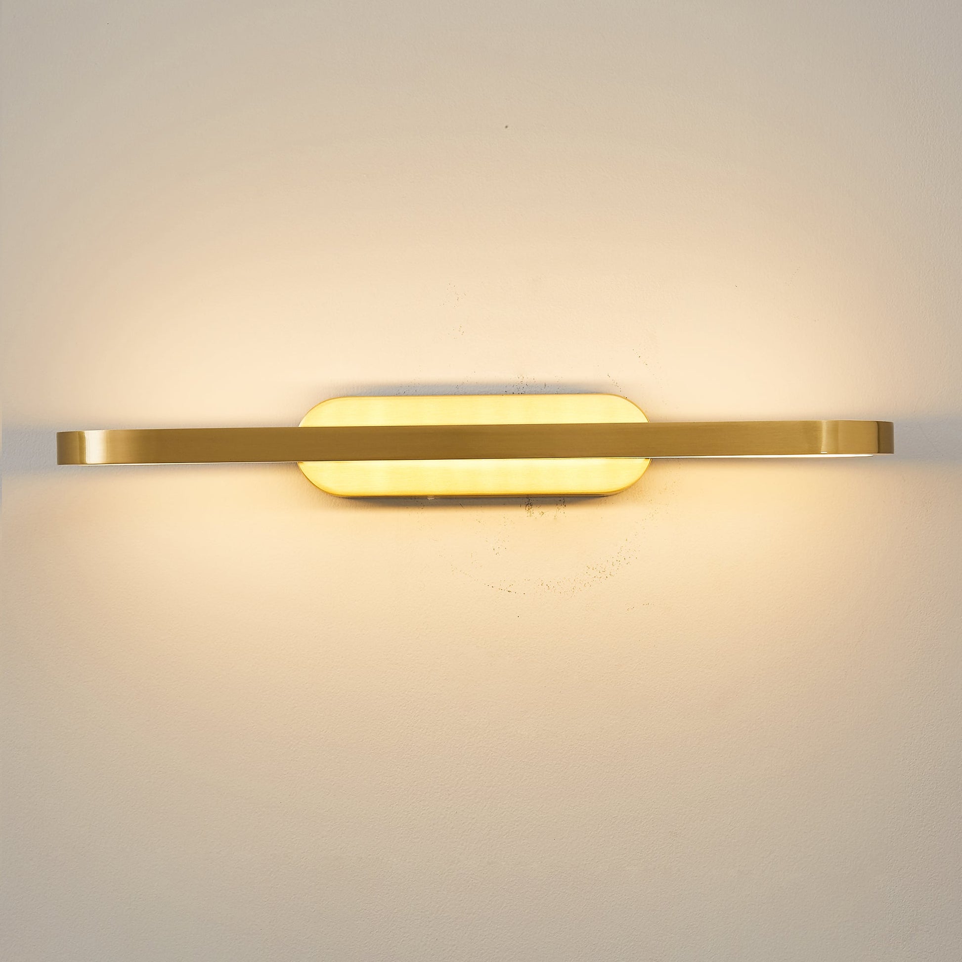 The oval silhouette of the Gianni LED Wall Lamp against a dark wall.