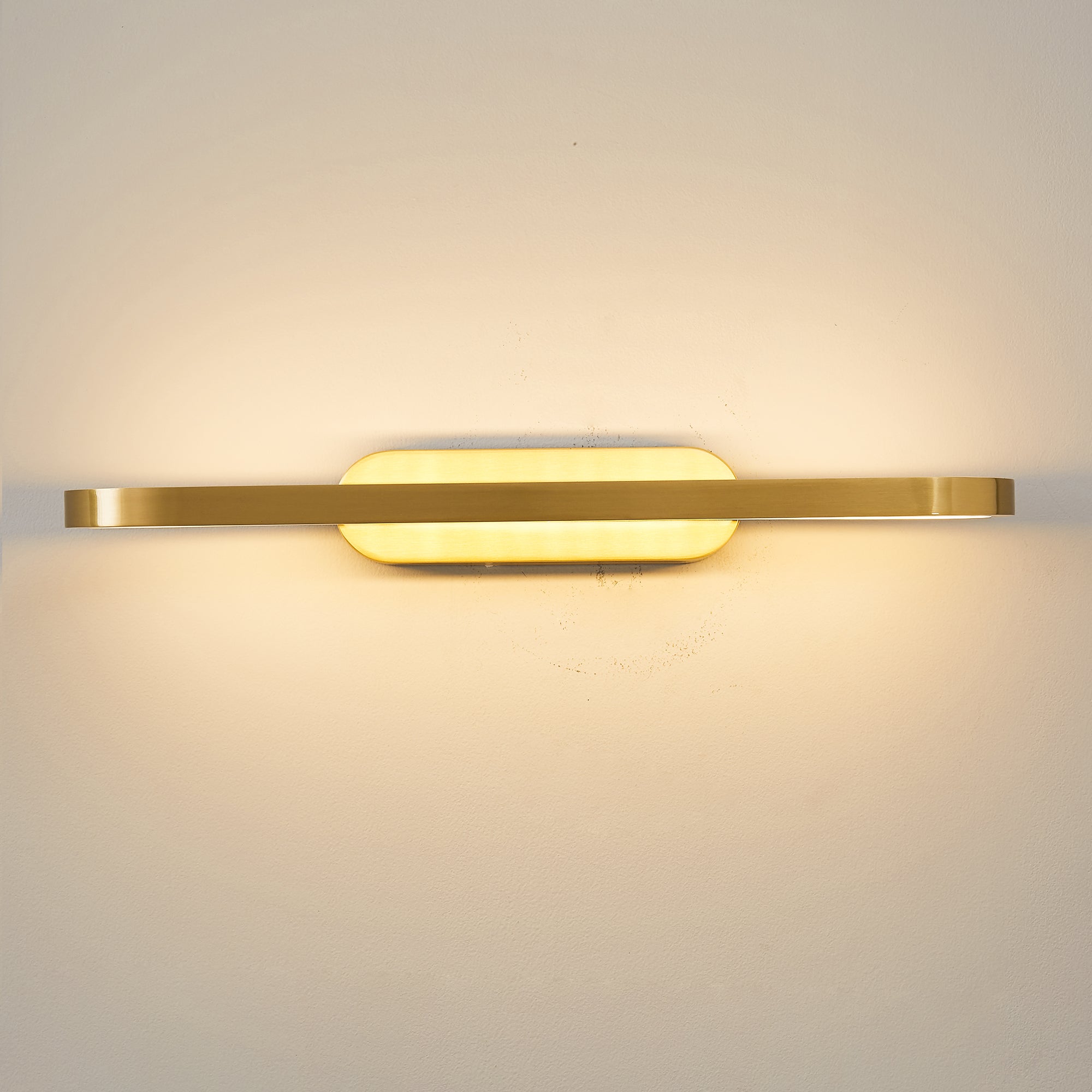The oval silhouette of the Gianni LED Wall Lamp against a dark wall.