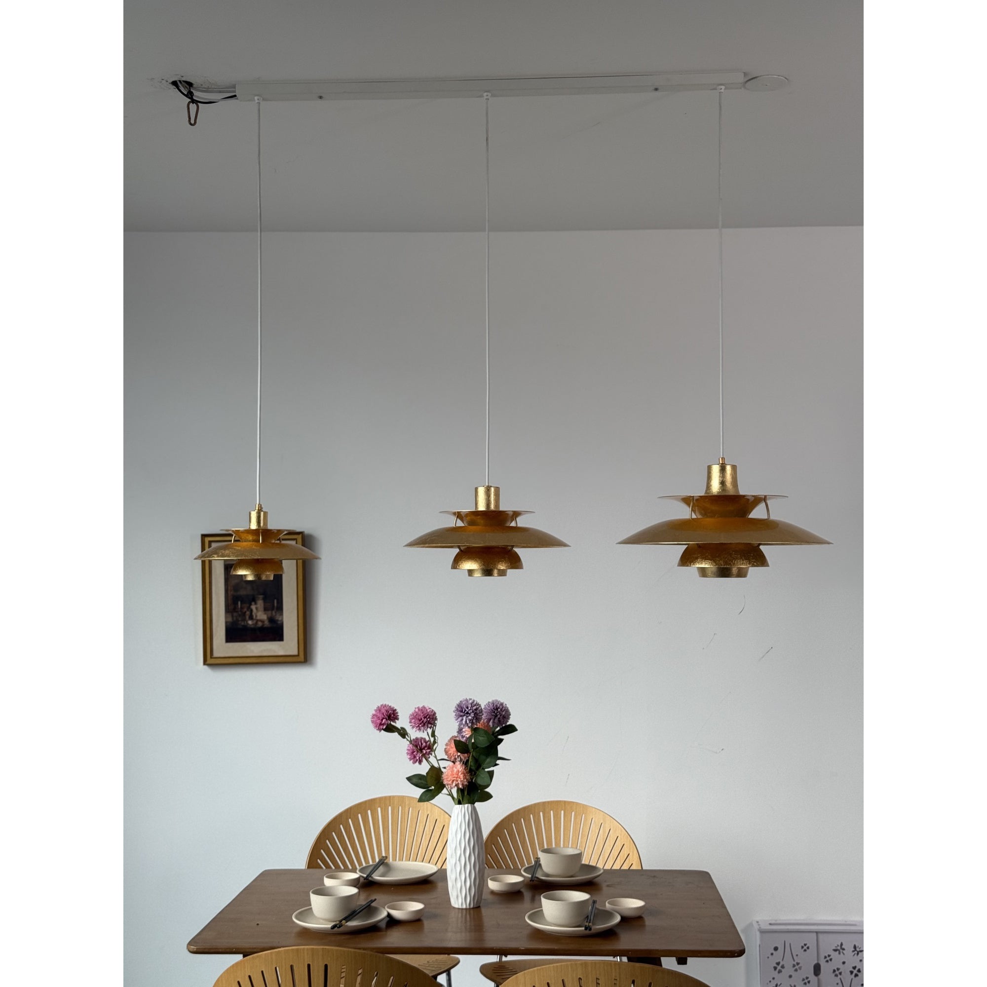 A pair of silver foil lamps over a breakfast bar.