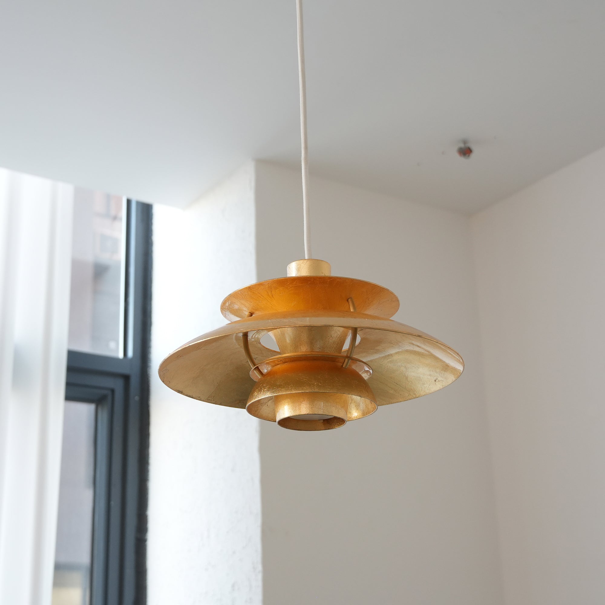 The Gold Foil PH Pendant Lamp viewed from the side against a neutral background.