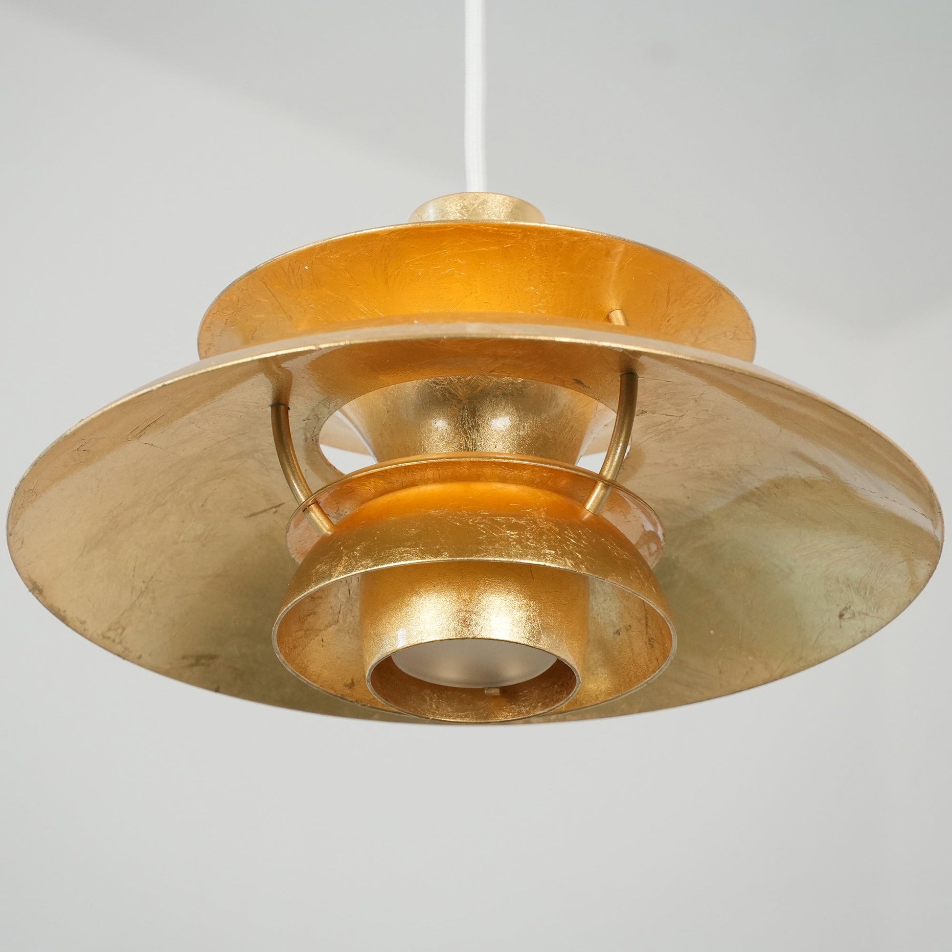 Angled shot of the gold foil pendant lamp, showing its depth.