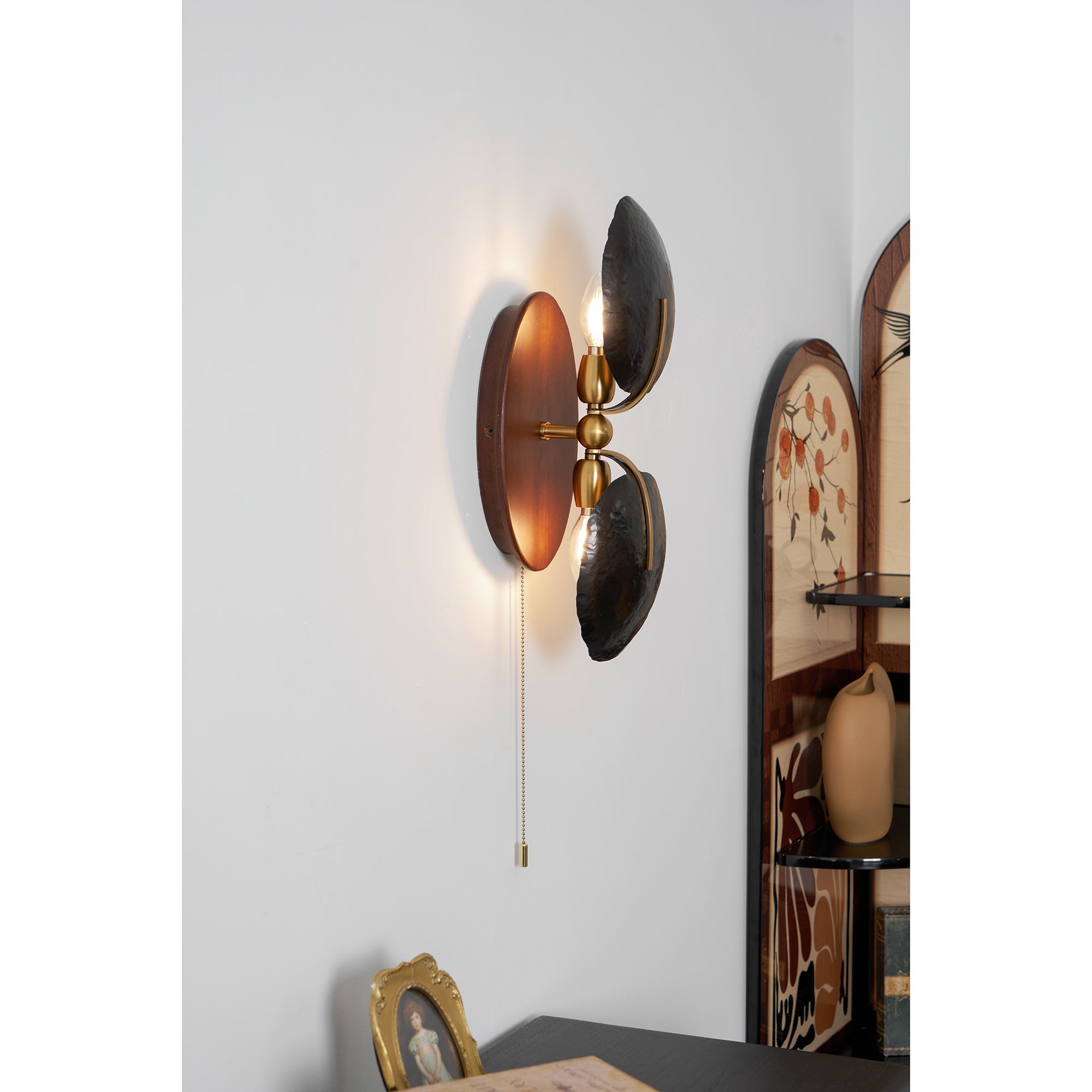 Greta Wall Lamp in gold, adding a touch of elegance to a room.