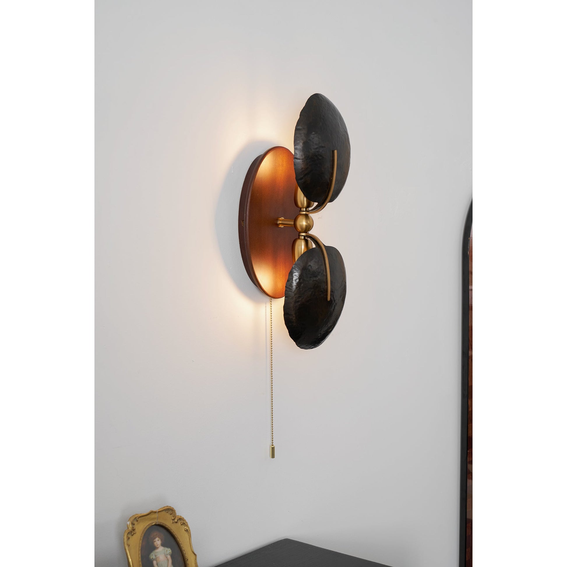 Lifestyle image of the Greta Wall Lamp next to a bed.