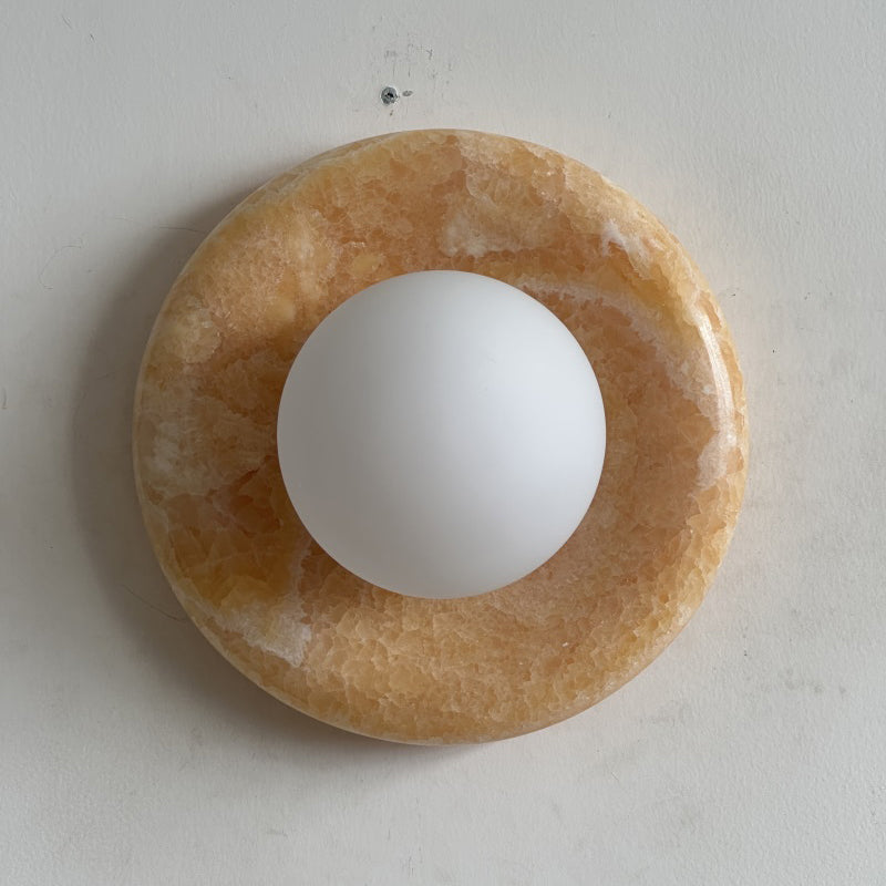 Front view of the Orli Yellow Onyx Sconce against a neutral wall.