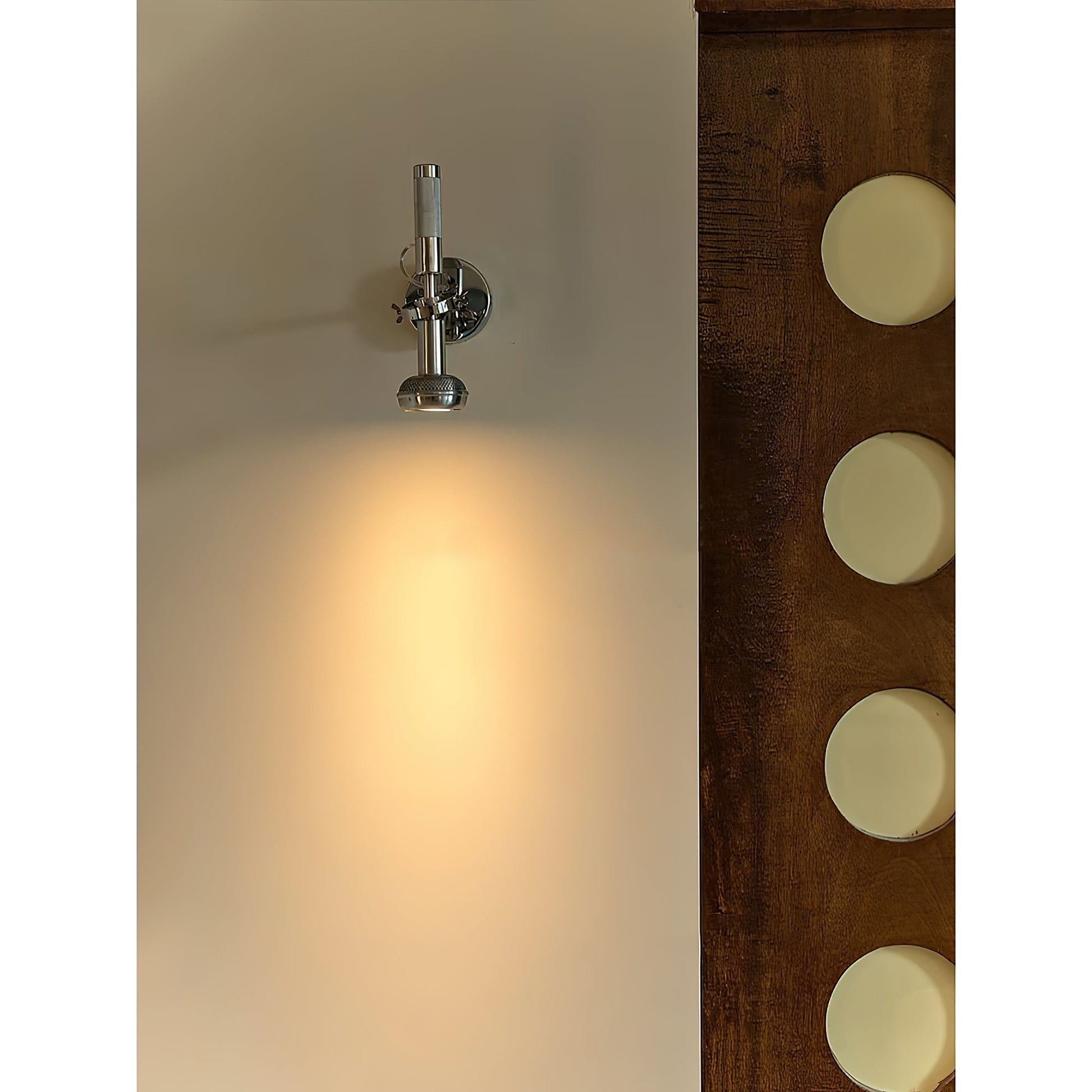 The sleek chrome finish of the Halva Wall Lamp reflecting light.
