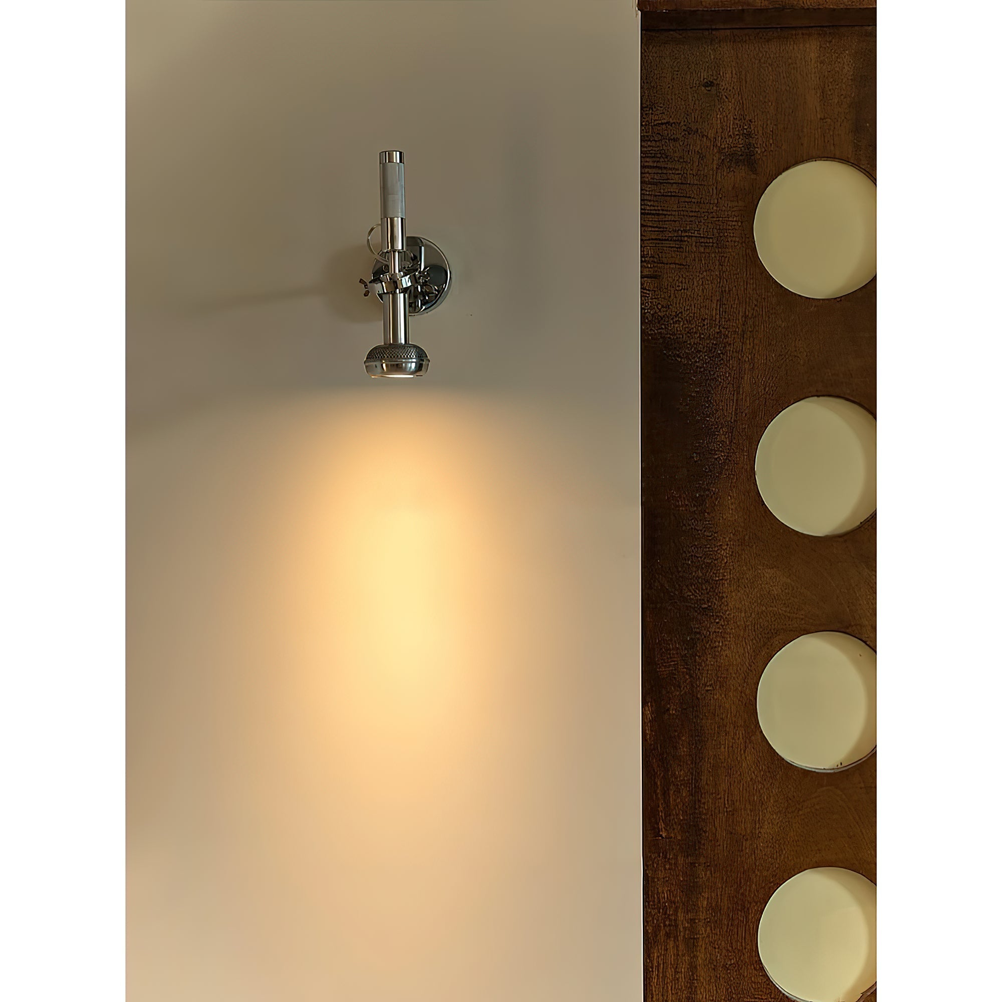 The sleek chrome finish of the Halva Wall Lamp reflecting light.