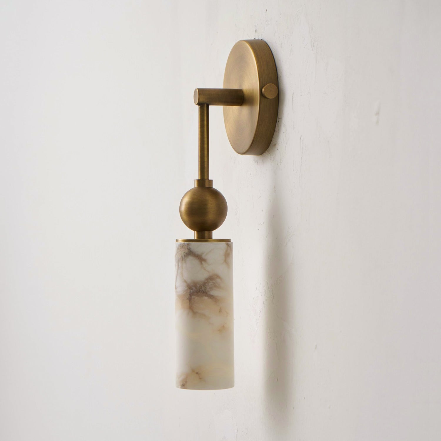 Lifestyle image of the 2-head brass wall lamp in a dining area.