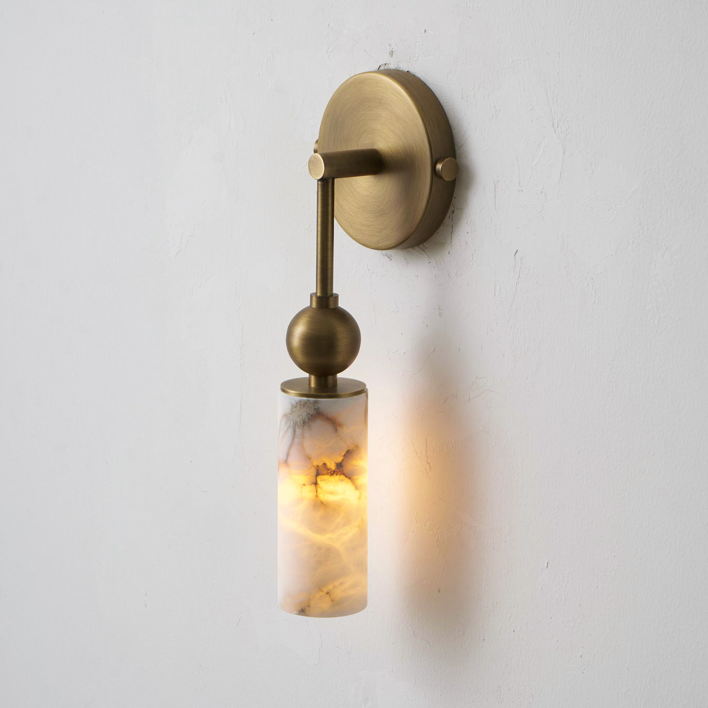 The cylindrical alabaster shade glowing warmly.
