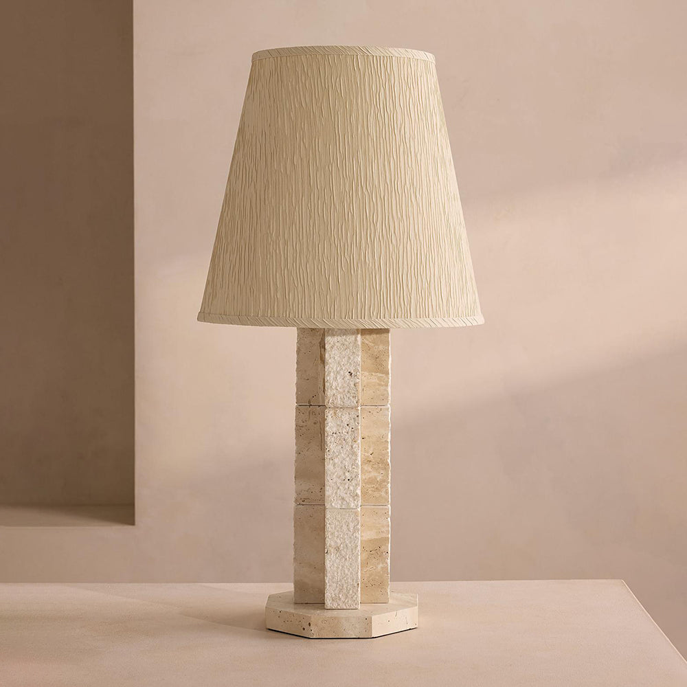 Close-up view of the natural textured travertine stone on the lamp's base.