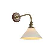 Heirloom ceramic wall lamp with a white shade and brass arm.