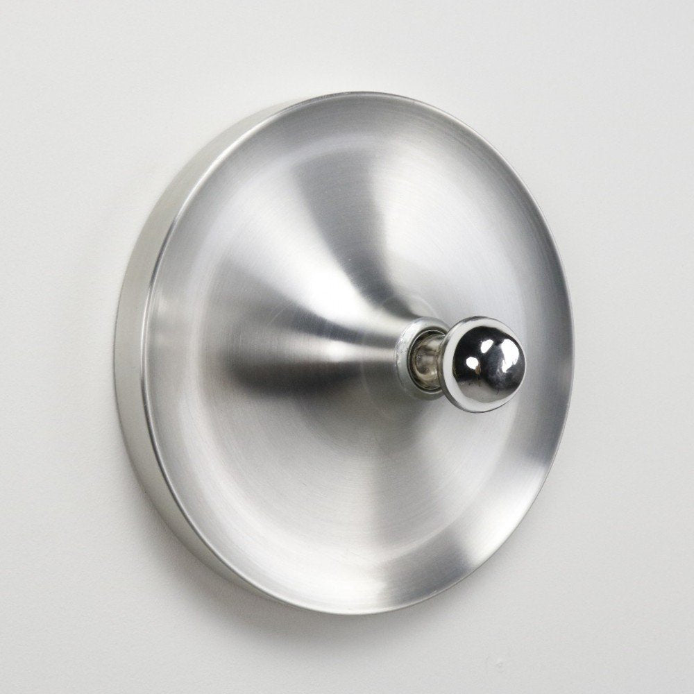 The lamp's reflection on a glossy surface, highlighting its finish.