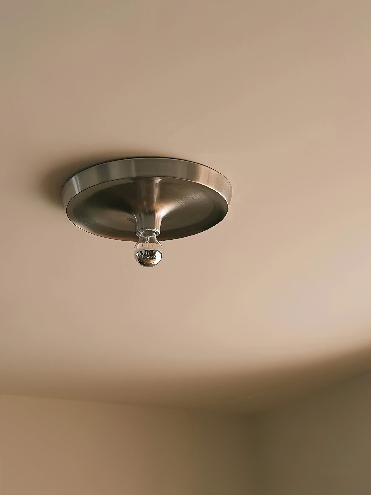 Angled perspective of the circular Honsel Leuchten wall lamp.