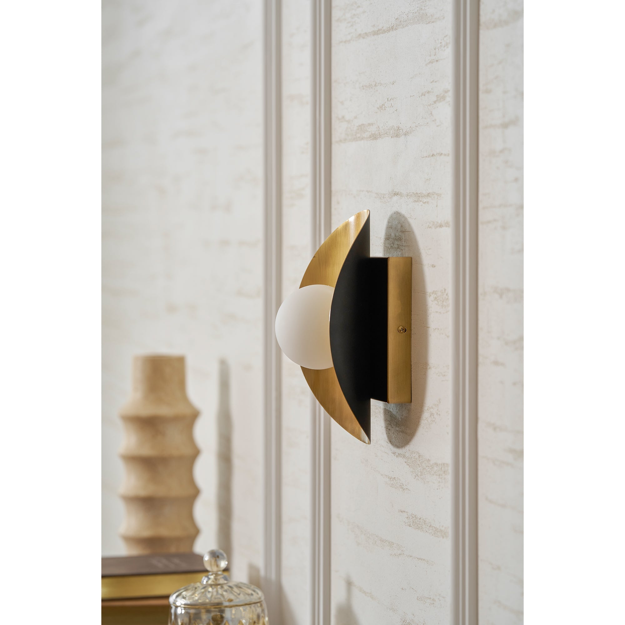 The brass Hopper Wall Lamp in a bedroom setting.