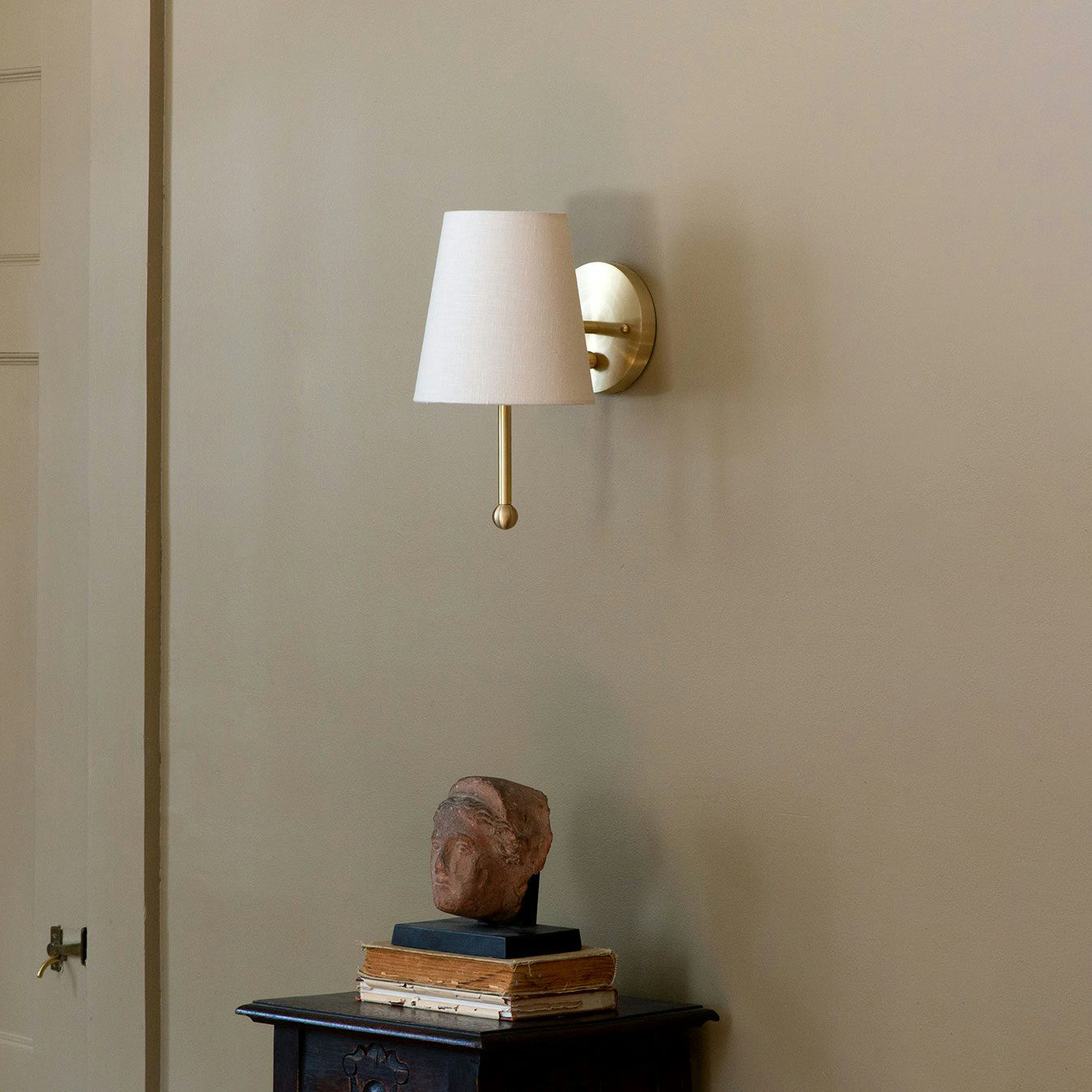 Close-up of the House Wall Lamp's brass fixture and linen shade texture.