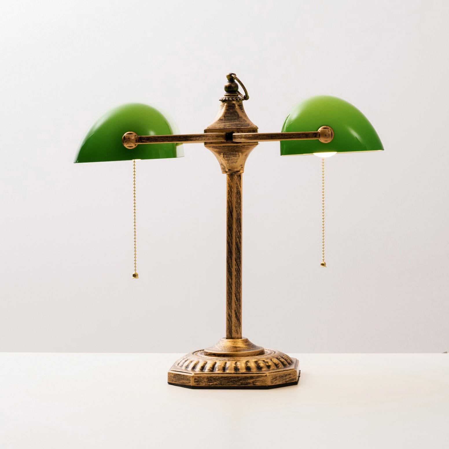 The green glass shade diffusing a warm light.
