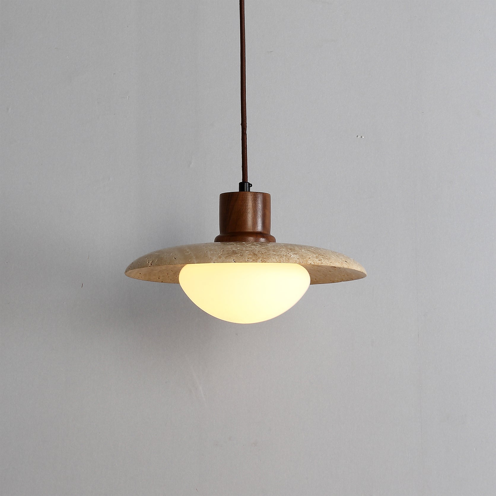 A detailed view of the yellow travertine material of the pendant lamp.