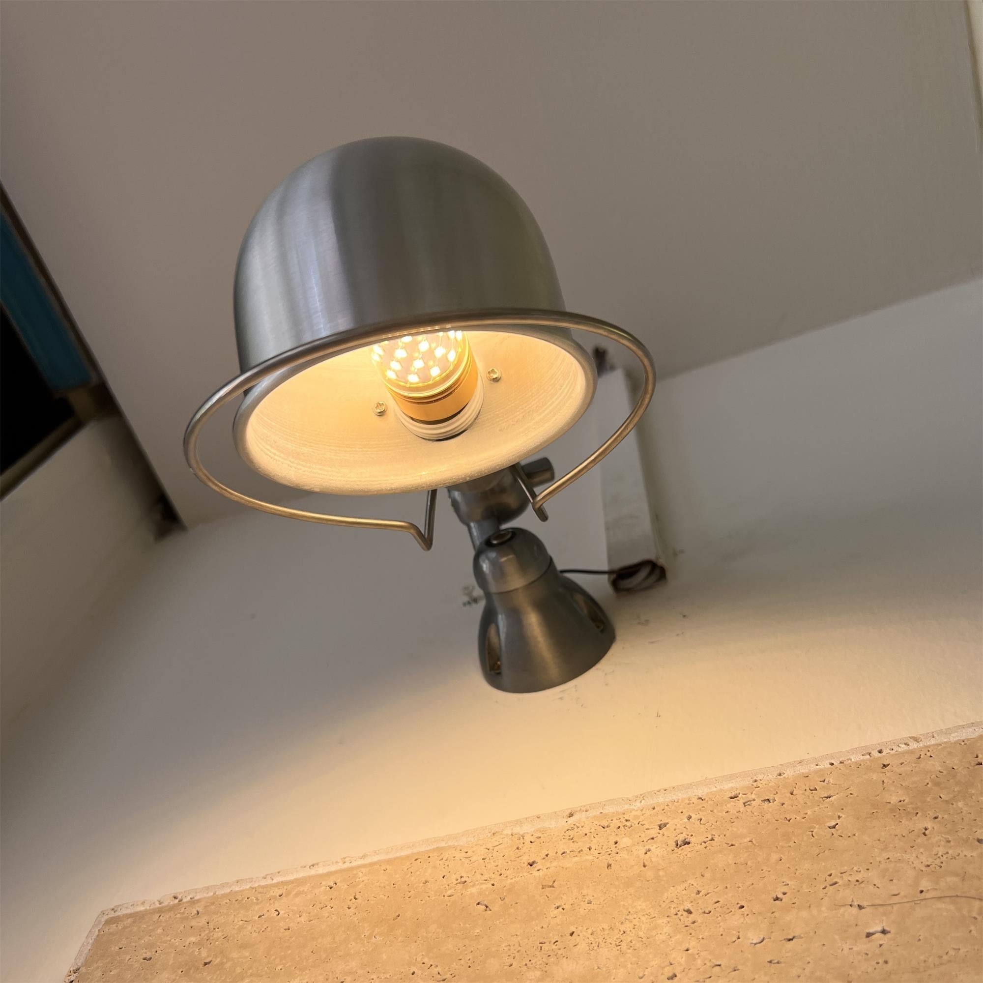 The silver wall lamp mounted on a light-colored wall.