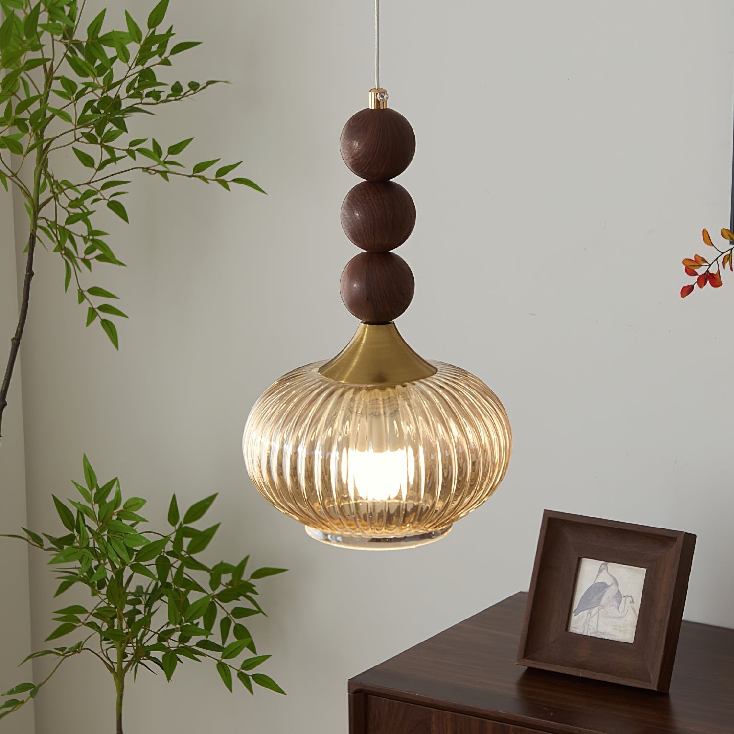 The Kaydan Pendant Lamp hanging in a modern living room, casting a warm light.