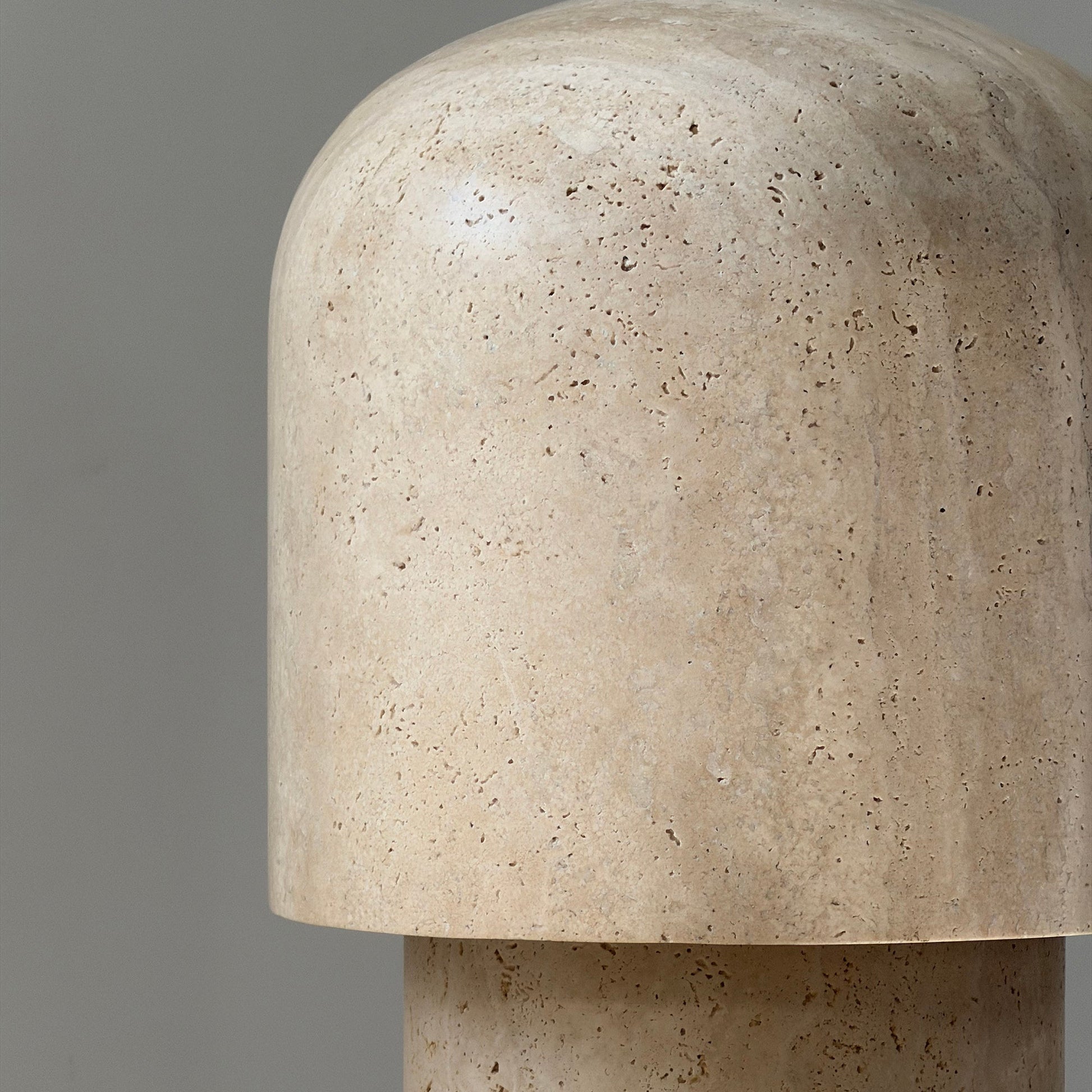The Kennett Travertine Table Lamp displayed on a wooden console table.