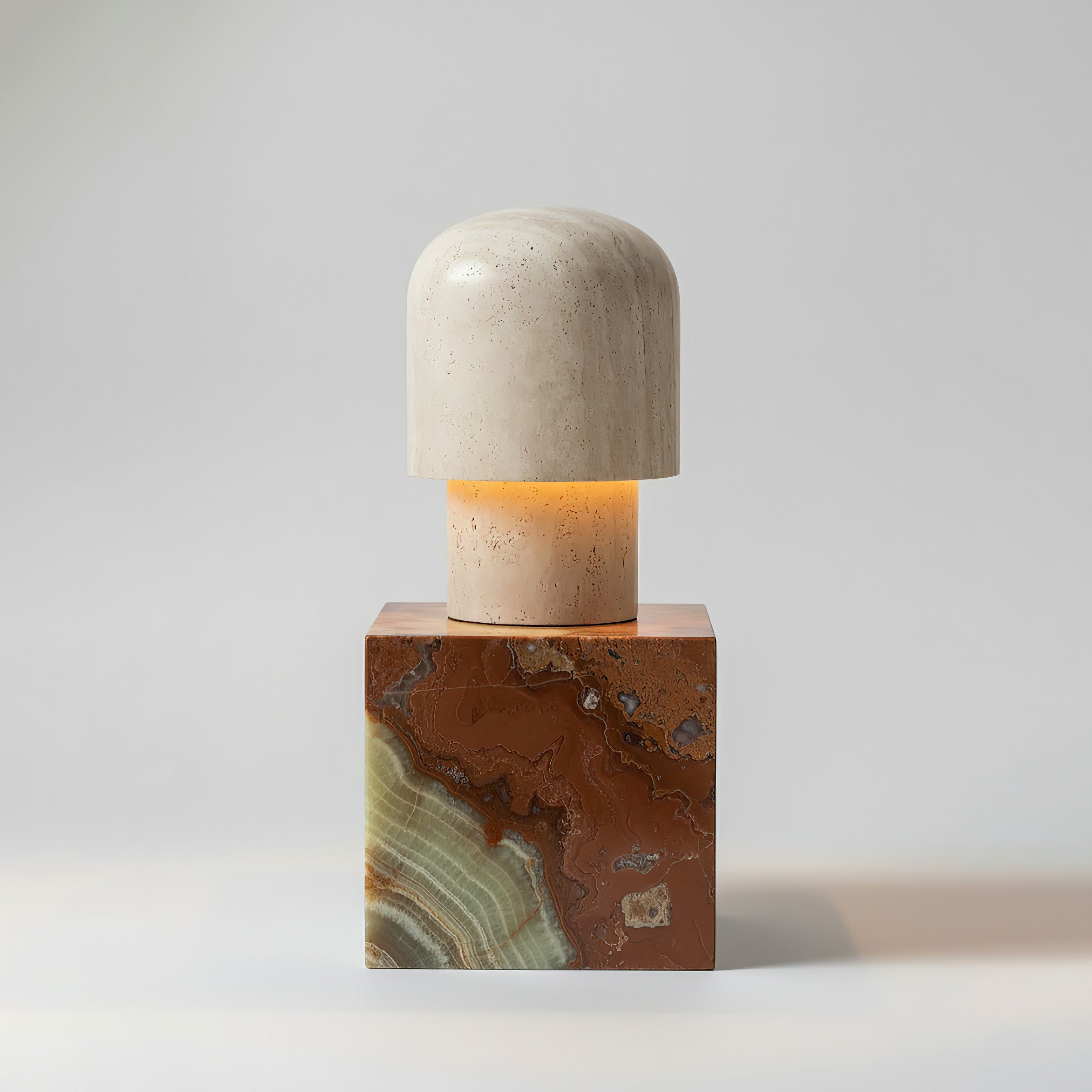 Angled view of the sculptural base of the travertine lamp.