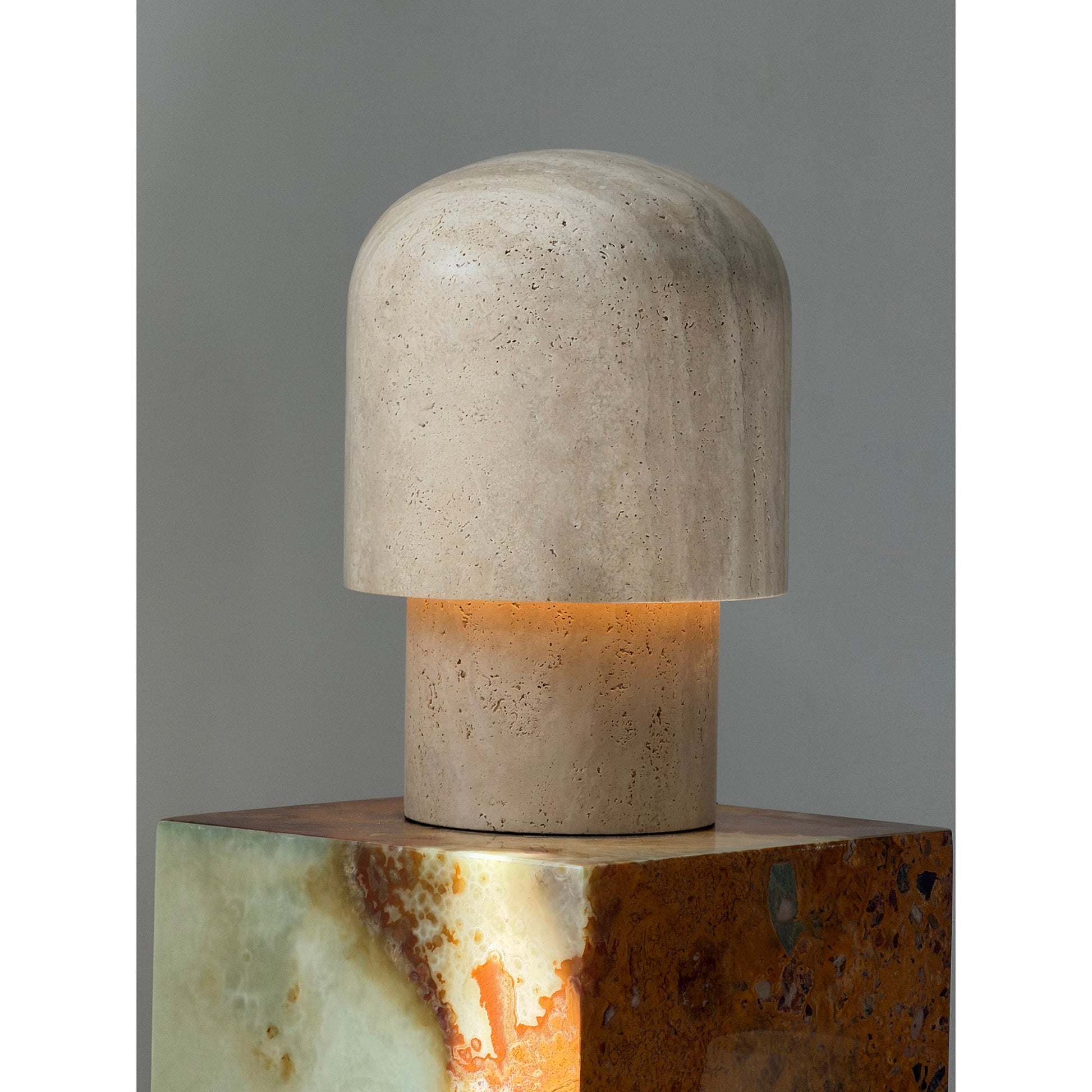 The beige travertine lamp against a dark wall for contrast.