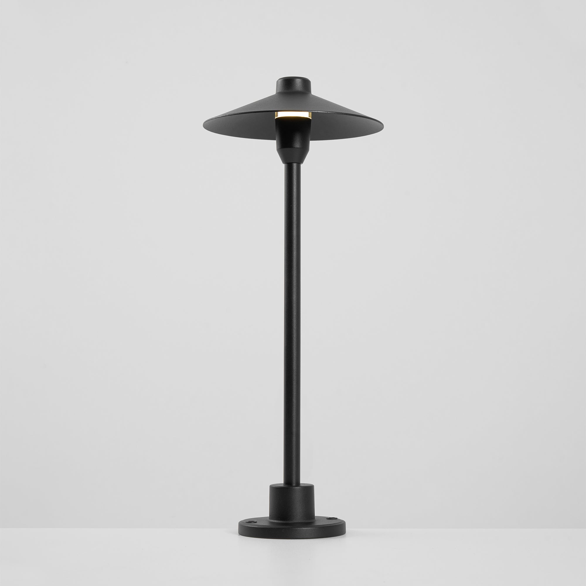 The lamp's cone shade and its light diffusion.