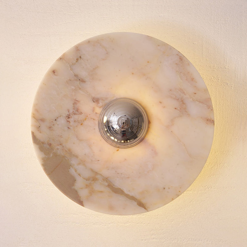 Circular green marble wall lamp, front view.