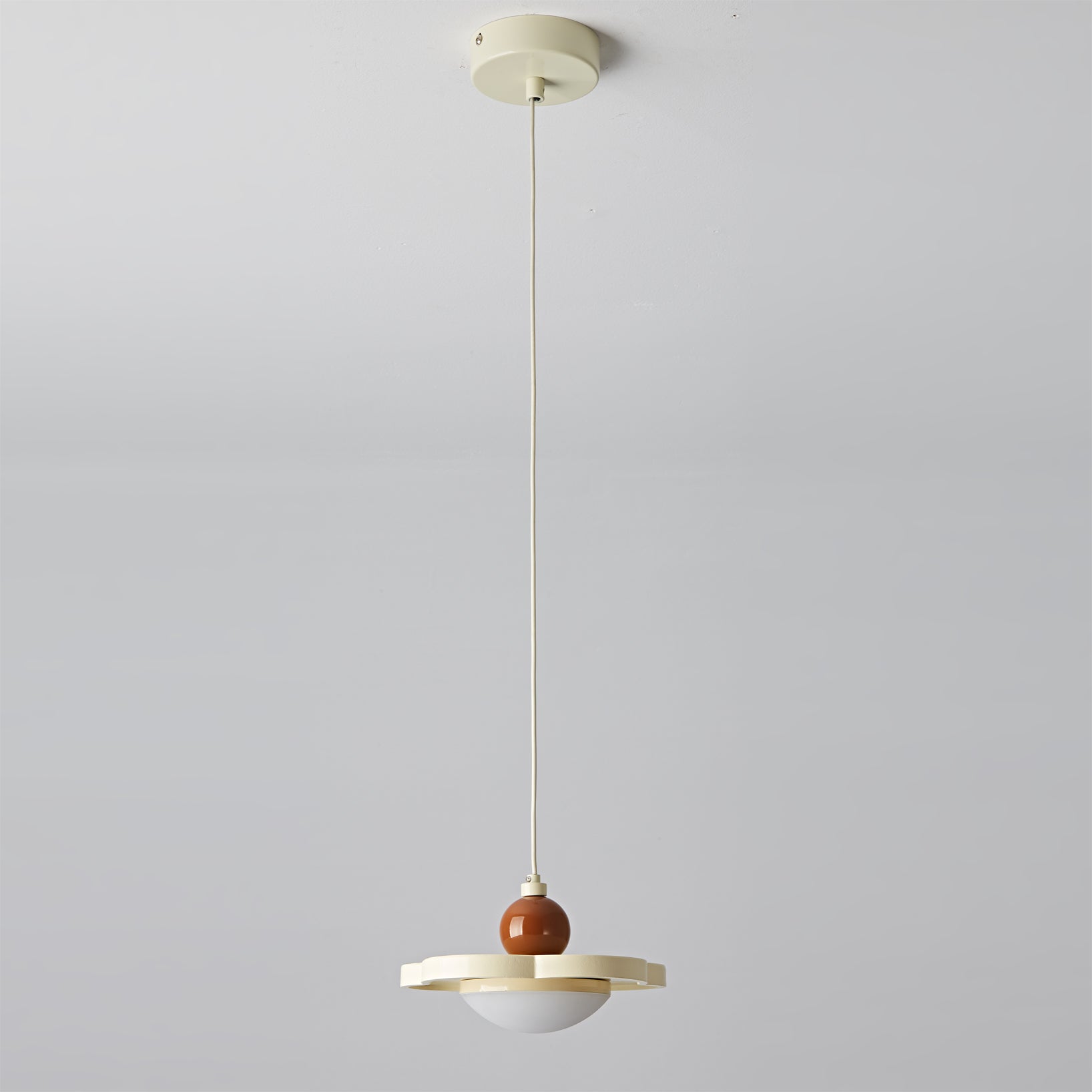 The pink Laguna Pendant Light against a neutral wall.
