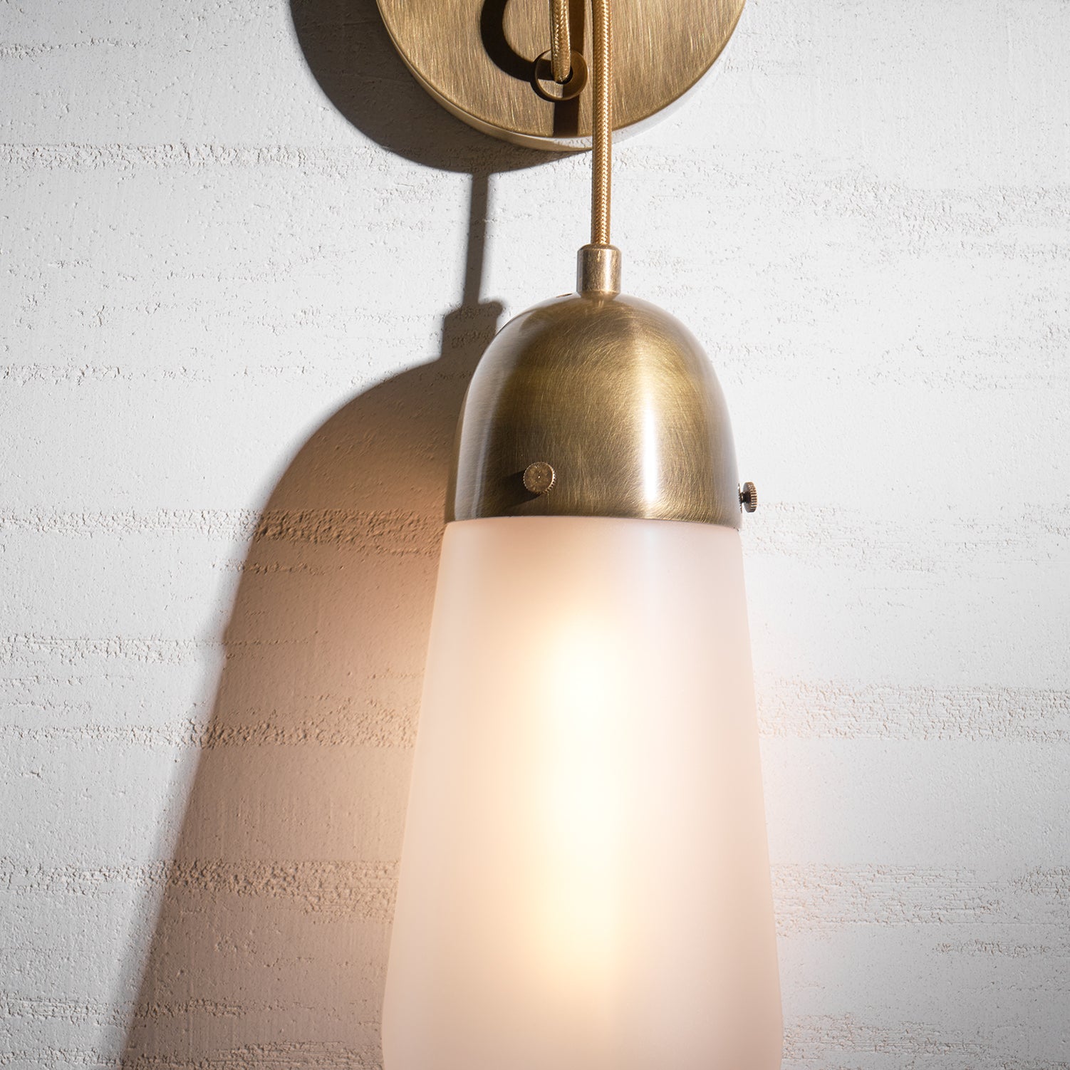 Lifestyle image showing the Lariat Wall Lamp over a small console table.