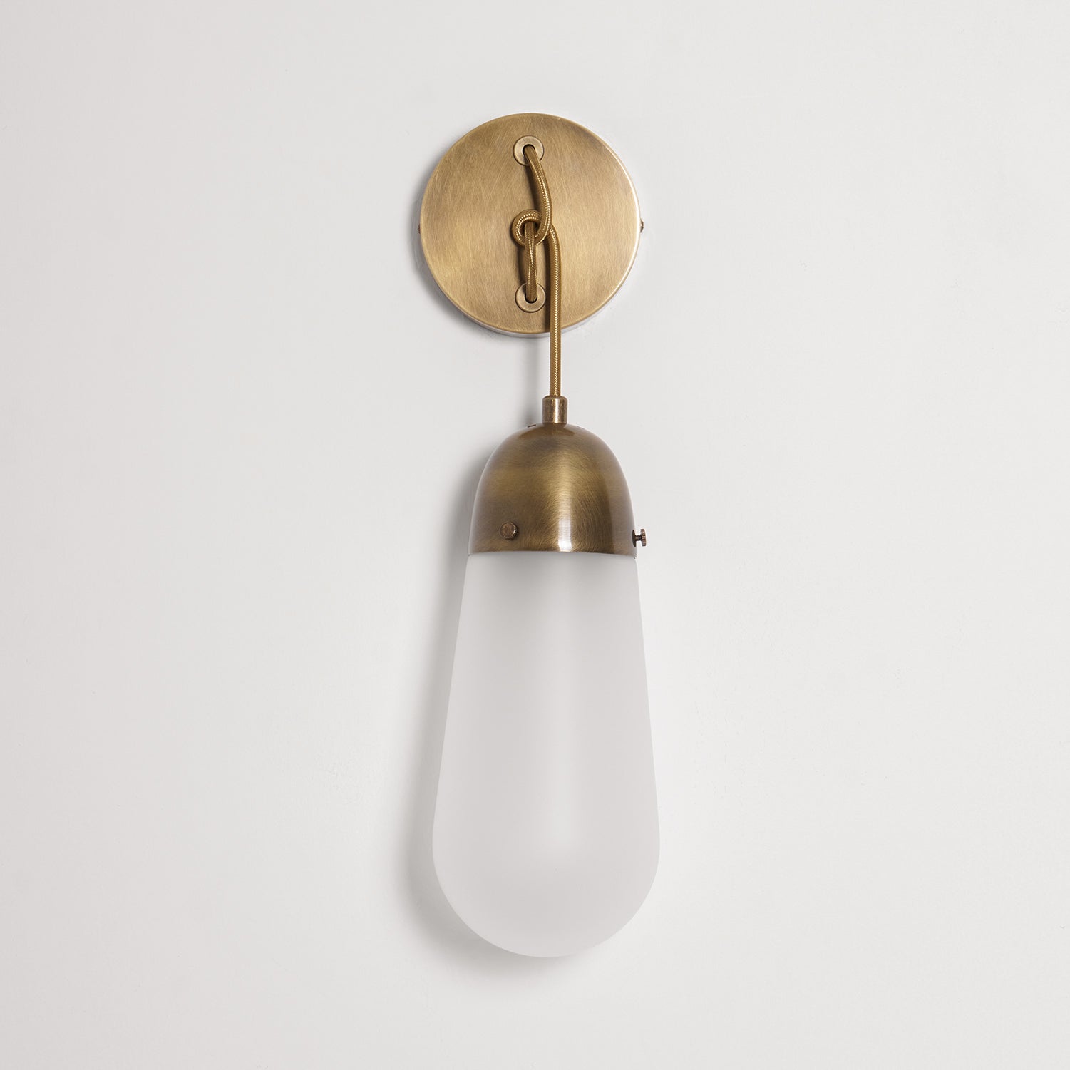 Lariat Wall Lamp casting a soft light in a cozy reading nook.