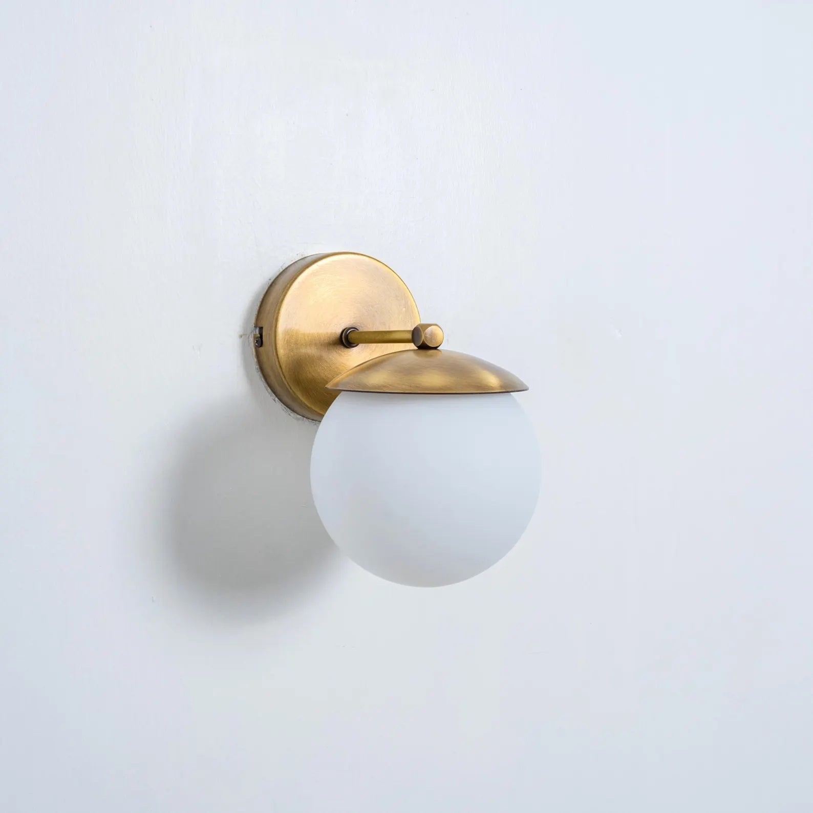 Lifestyle image of the Julep wall sconce above a nightstand.
