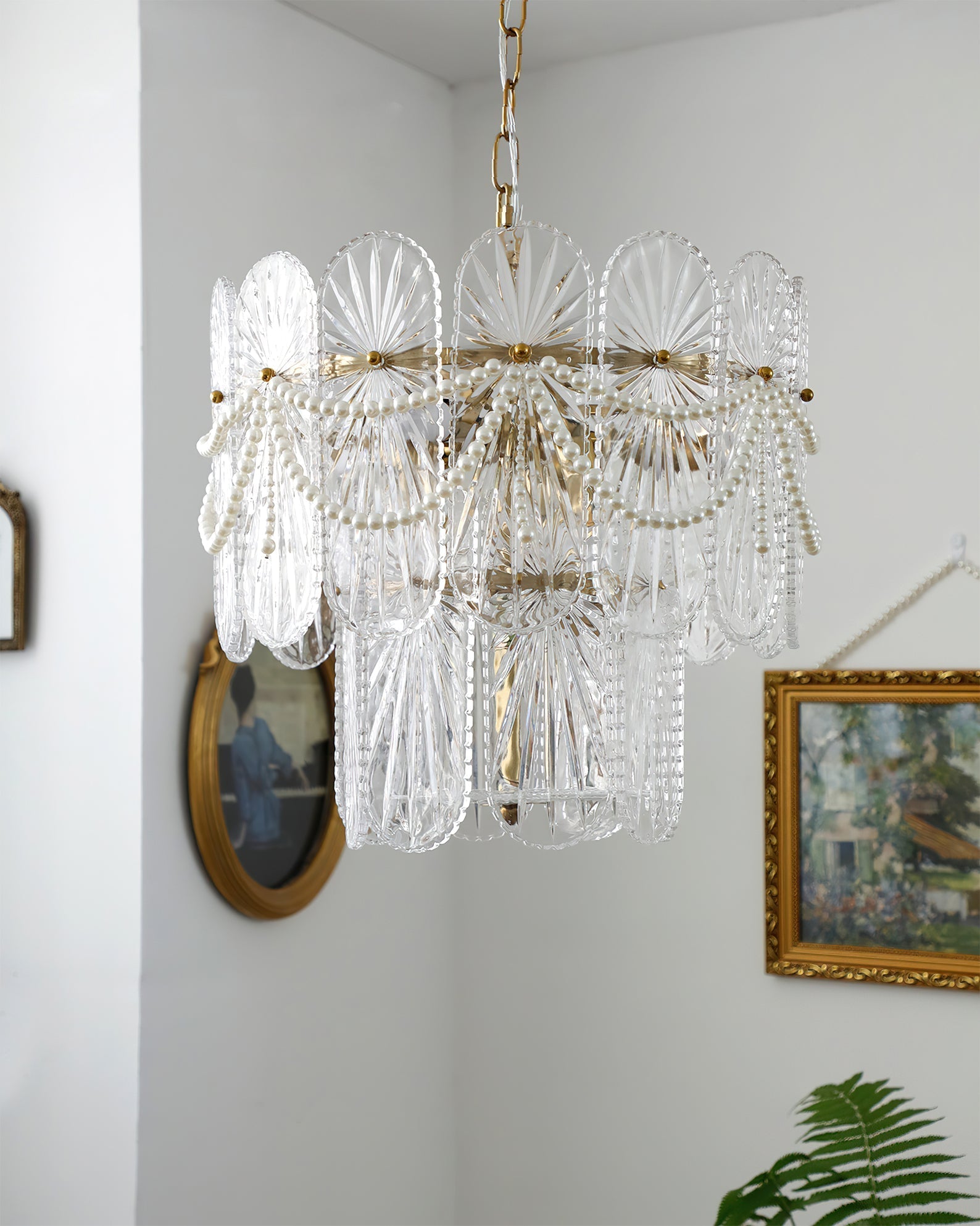 The chandelier unlit, highlighting the clear glass and gold finish.