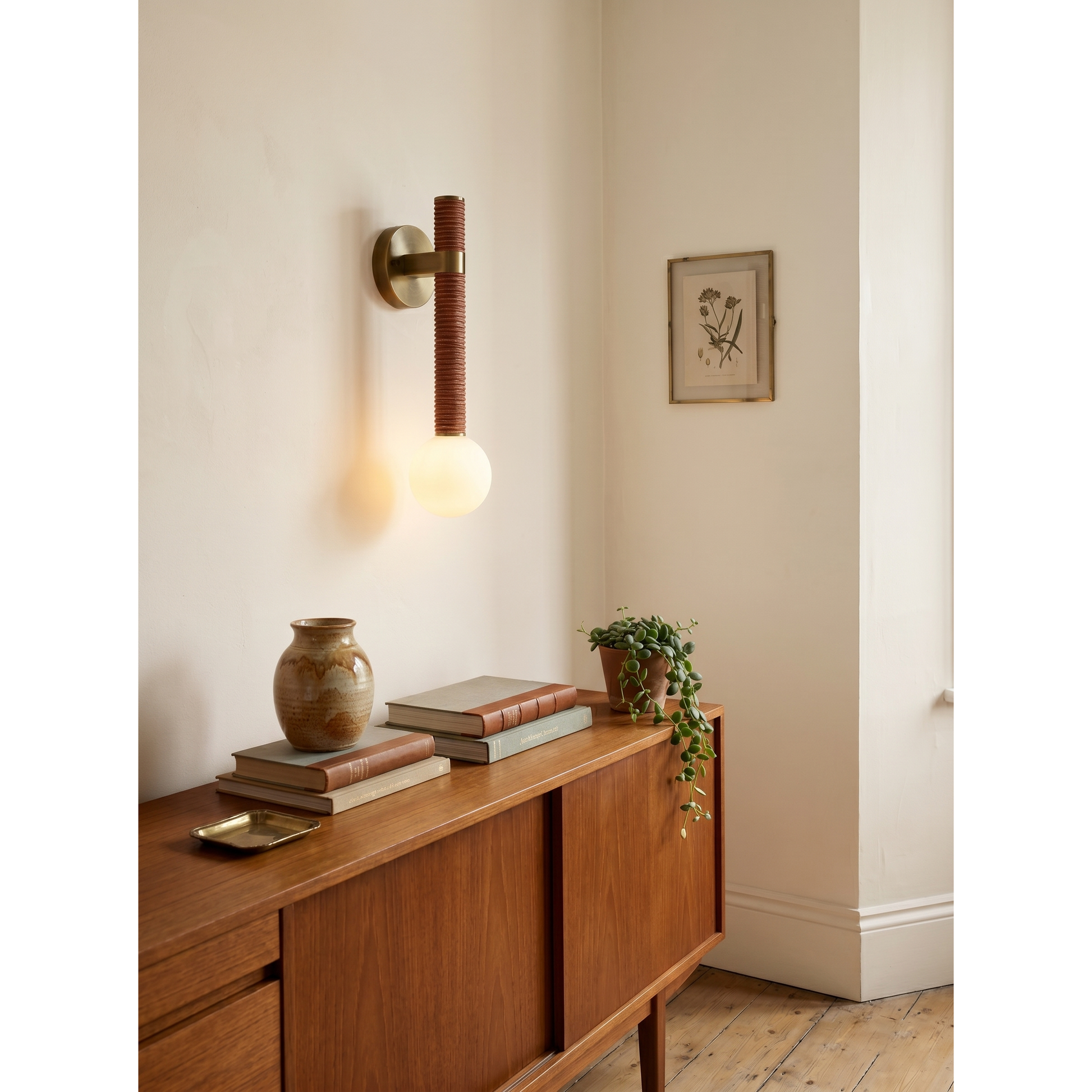 The glass globe diffuser of the Threadline sconce, showing the warm glow.