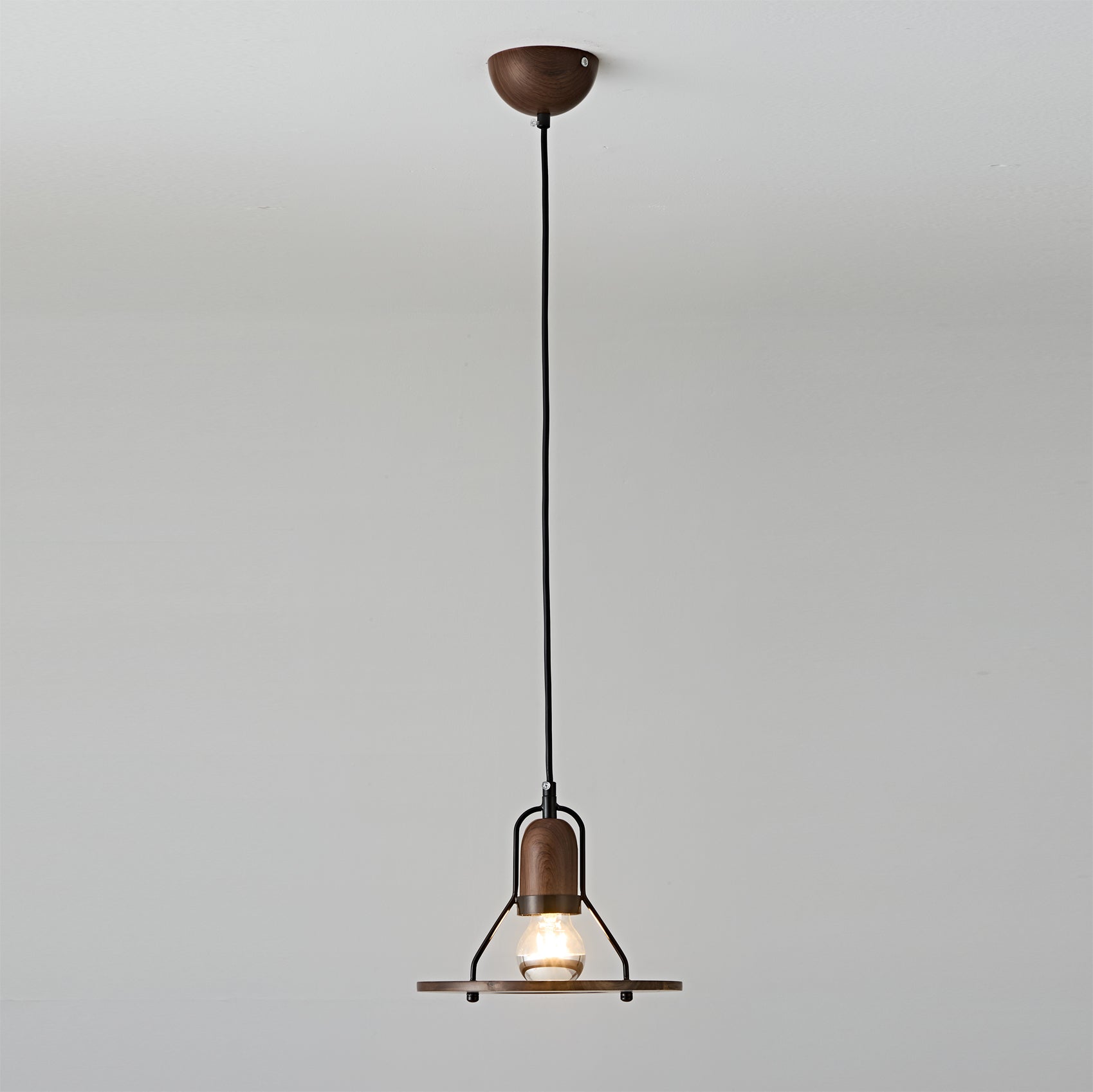 Close-up view of the Lioren Pendant Lamp's metal shade and walnut detail.