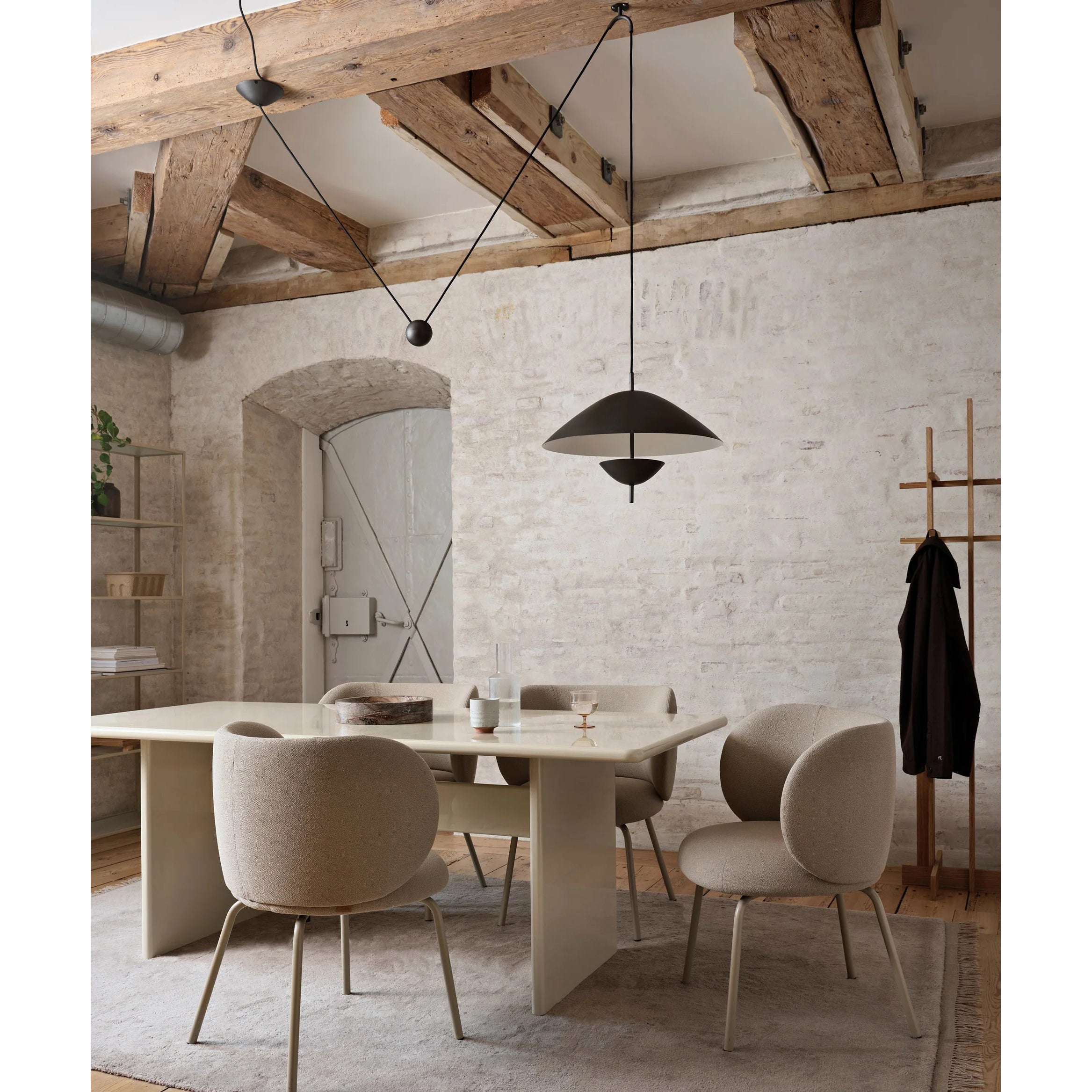 Beige Lod Pendant Lamp against a dark wall, creating a visual contrast.