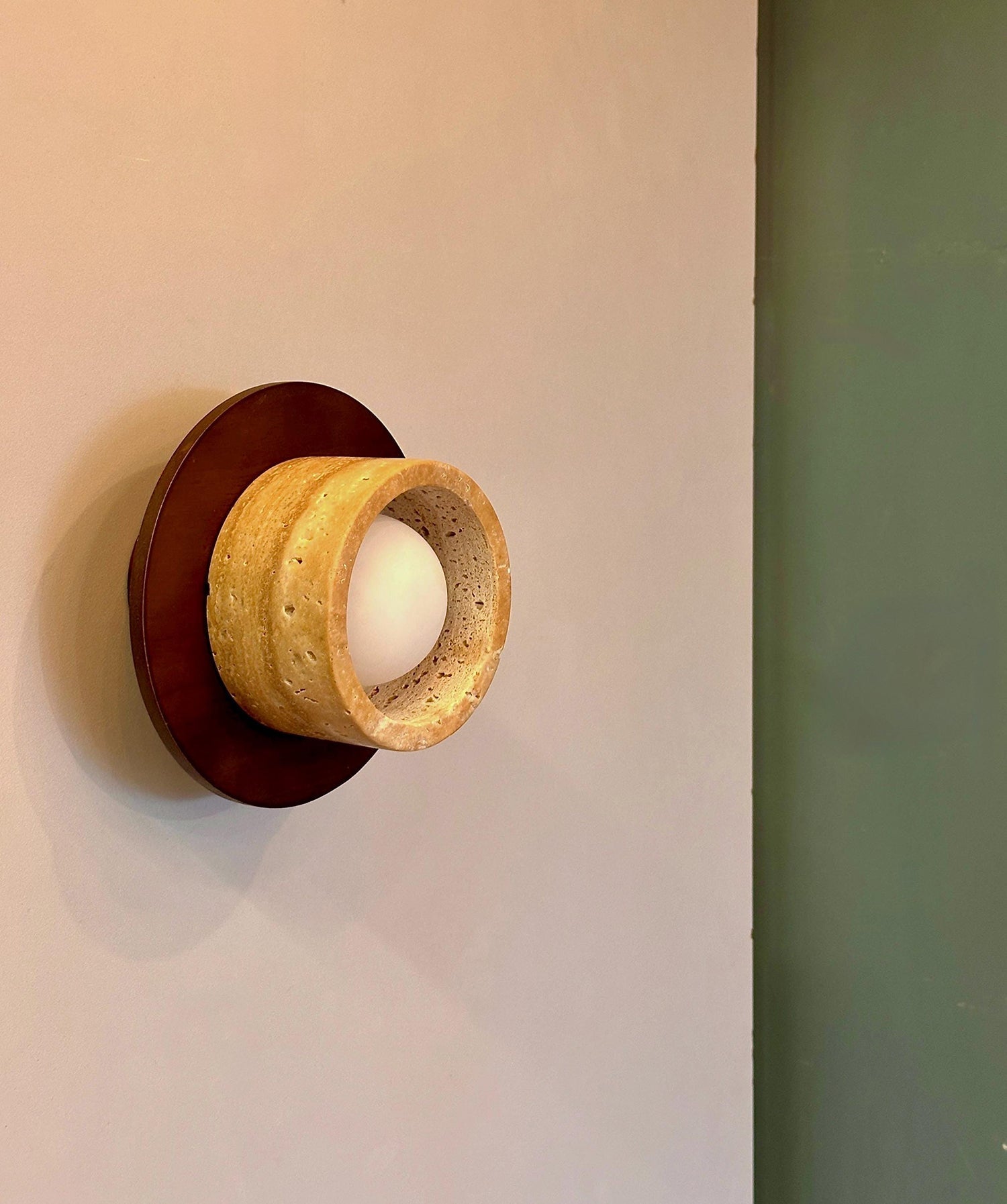 The wall lamp illuminated, casting a warm and inviting glow.