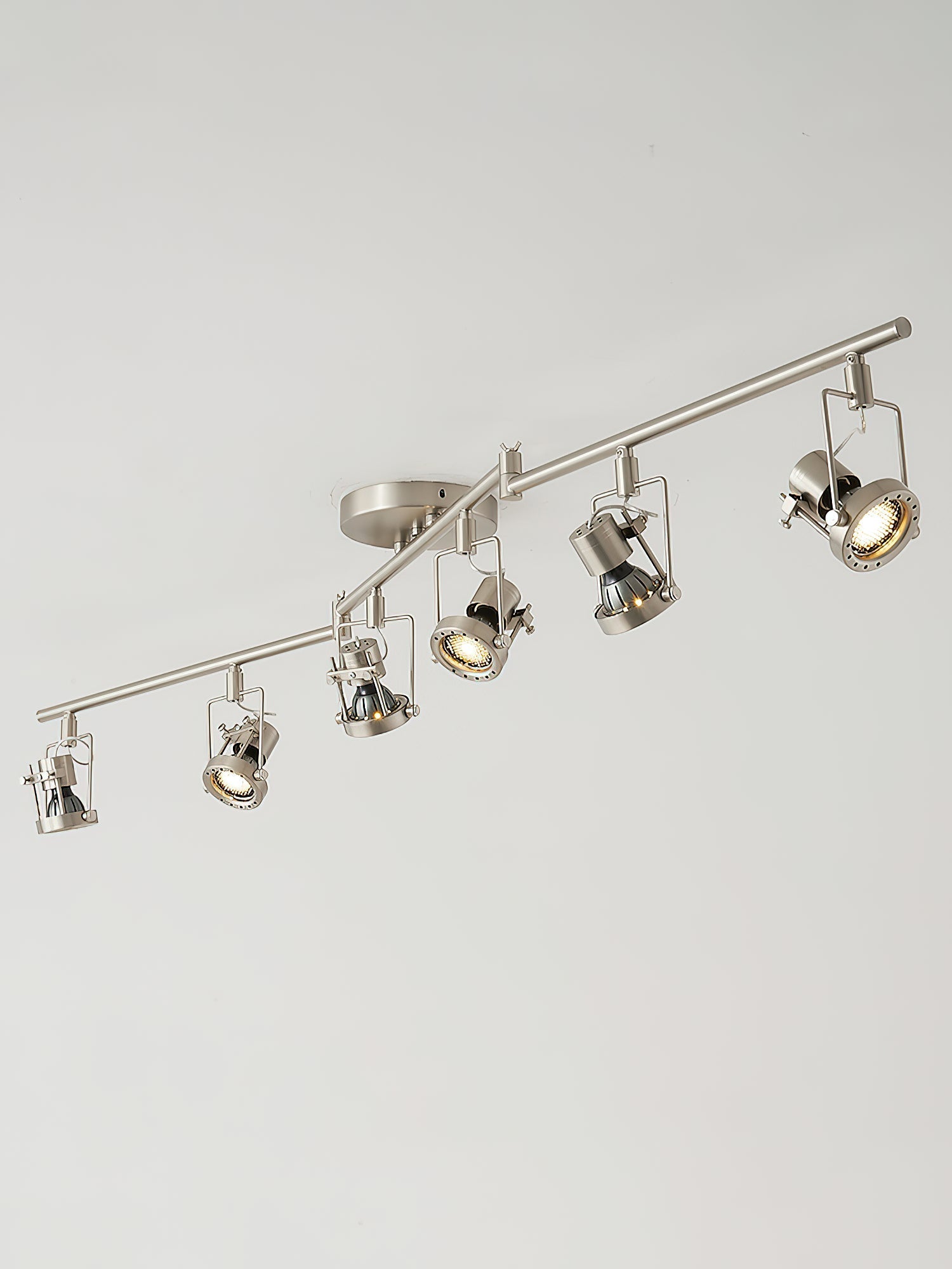 Close-up of the glass lampshade and metal fixture on the industrial track lamp.