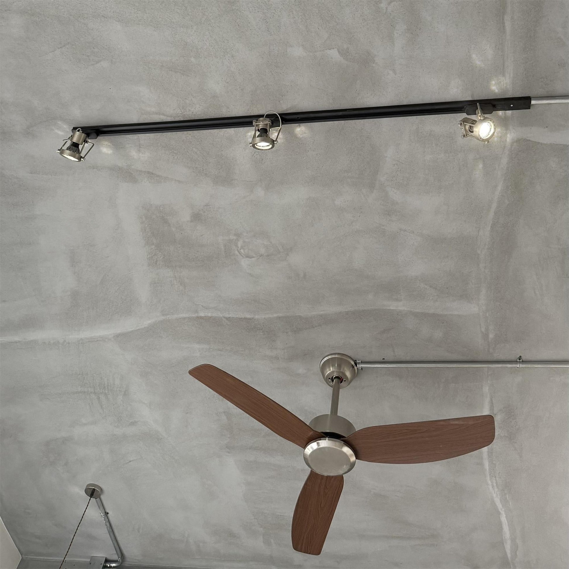 Industrial track light head tilted to highlight an object.