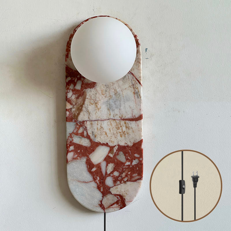 Close-up detail of the red marble body and the connection to the glass lampshade.