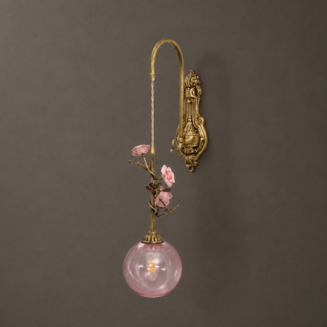 The wall sconce installed on a bright, white wall.